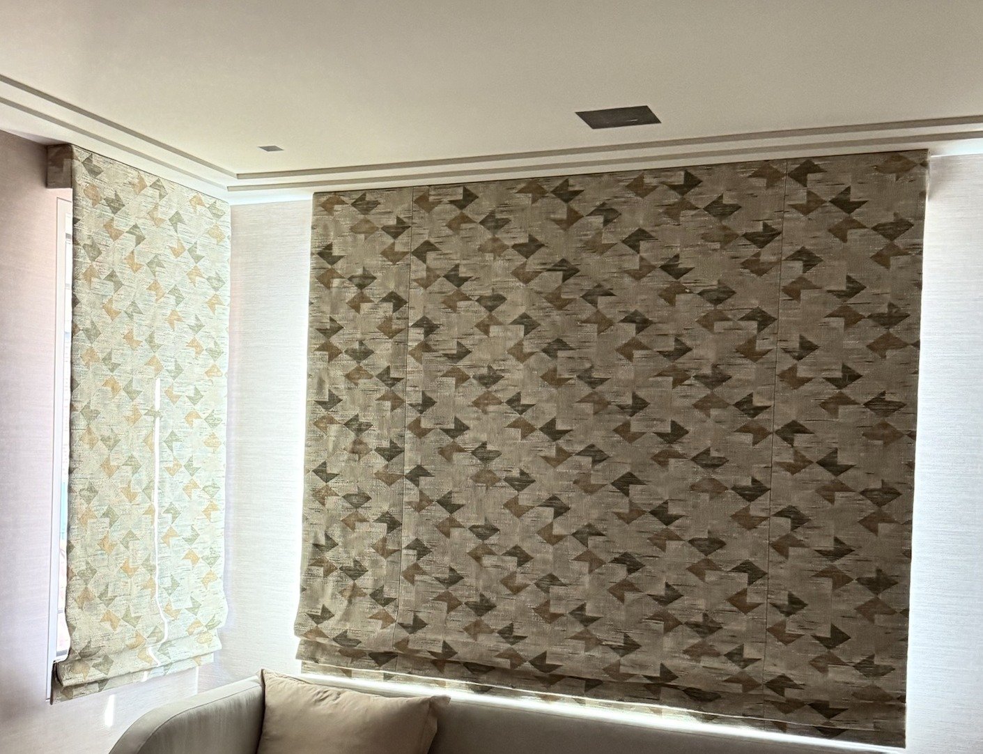 Custom flat Roman shades in a geometric patterned fabric on a corner window pair in New York