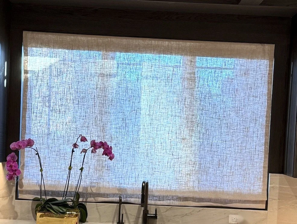 Sheer linen Roman shade over a kitchen sink window in New York