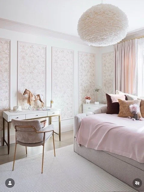 Soft blush pink girls bedroom with feather pendant light, patterned wallpaper and pink curtains NYC