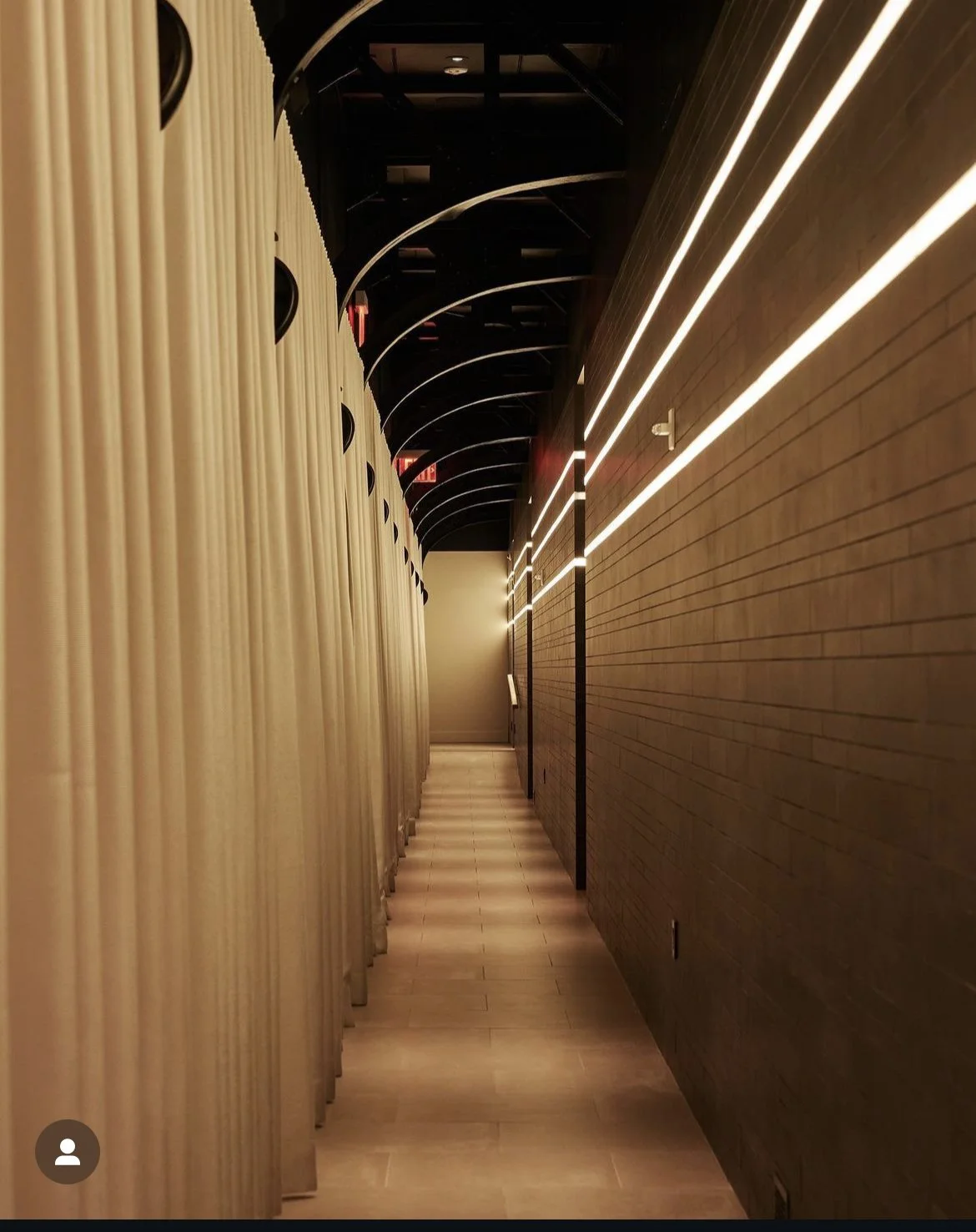 Commercial corridor with dramatic white drapery on curved ceiling track and LED strip lighting, NYC Rafael Interiors