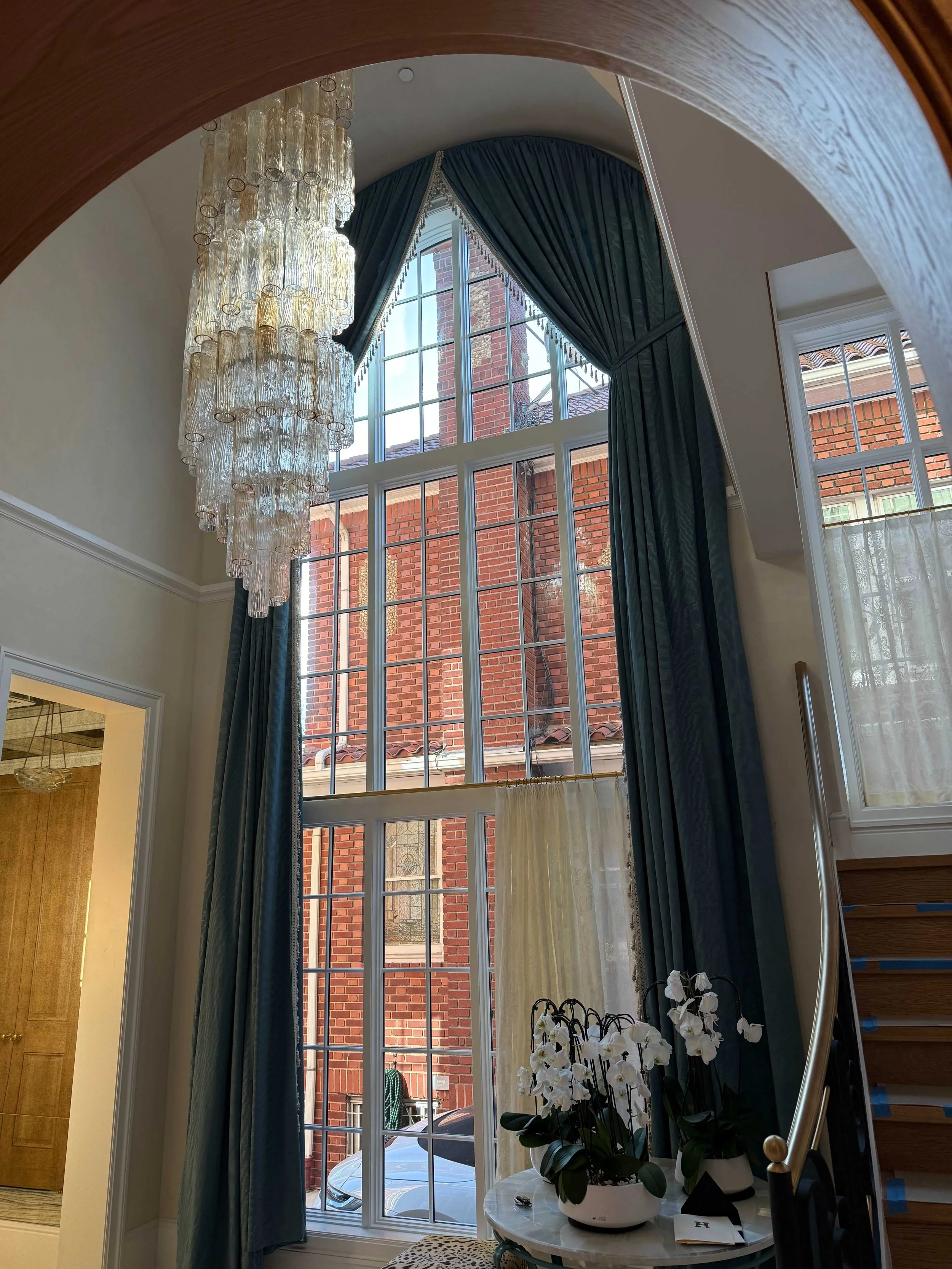 Grand foyer with floor-to-ceiling teal silk drapery, decorative swag valance and Murano glass chandelier NYC