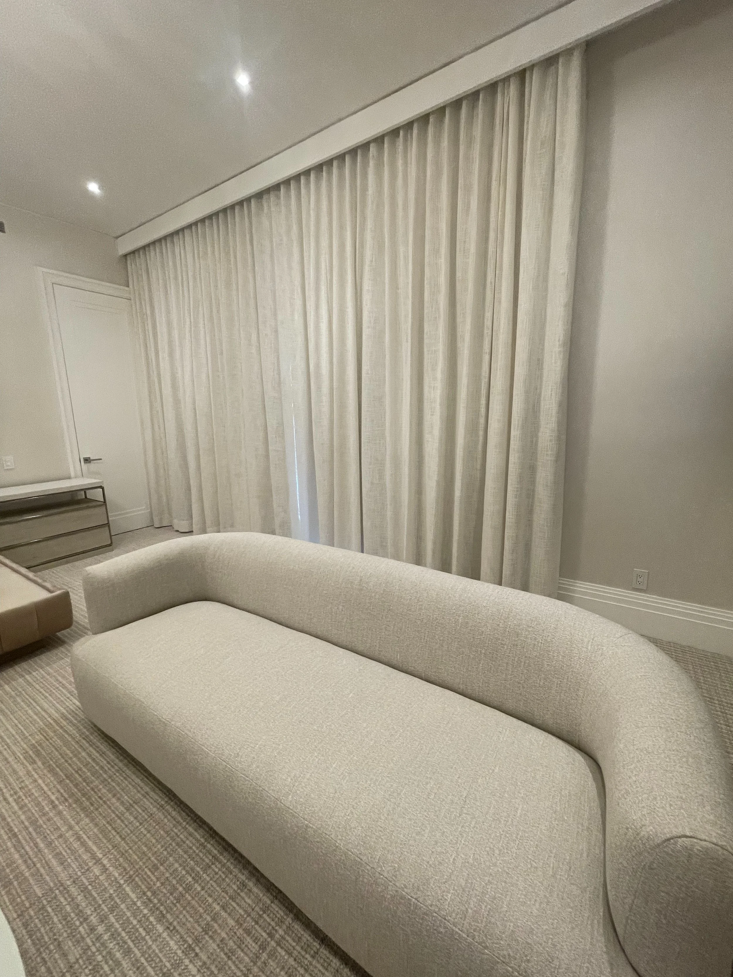 sitting-room-ivory-wave-fold-drapery-ceiling-track-curved-boucle-sofa-nyc.jpg