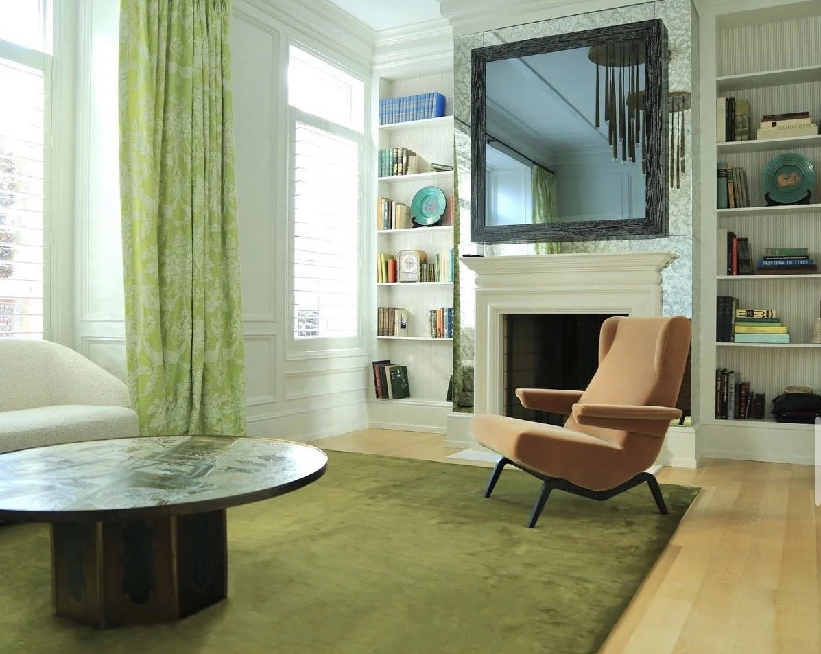 Eclectic living room with dark green walls, yellow toile drapery, fireplace and built-in bookshelves
