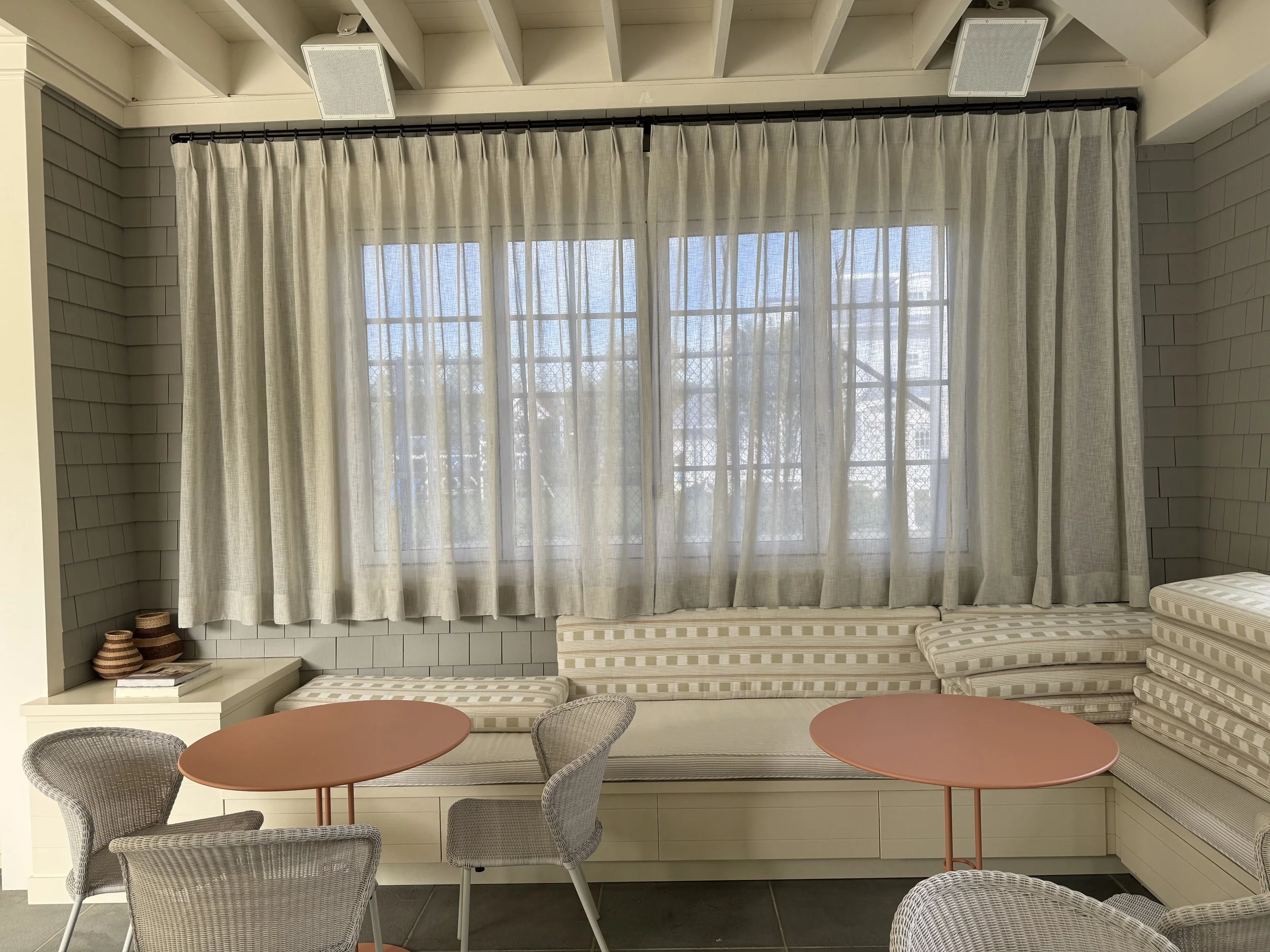 Custom pinch-pleat linen drapery on a ceiling-mounted track in a NYC-area living room
