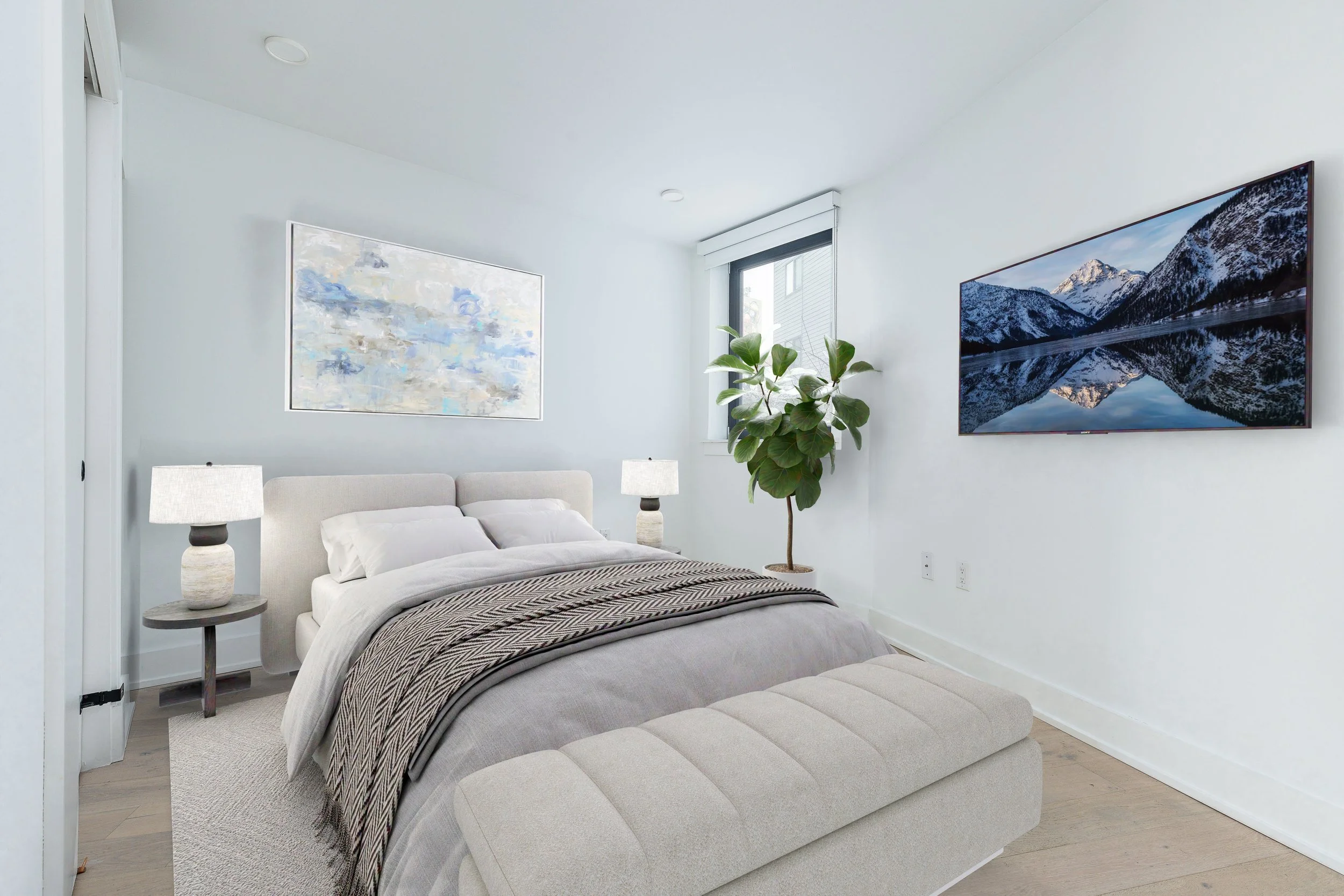 Modern bedroom with a bed, bedside lamps, artwork, a potted plant, a window, and a wall-mounted television