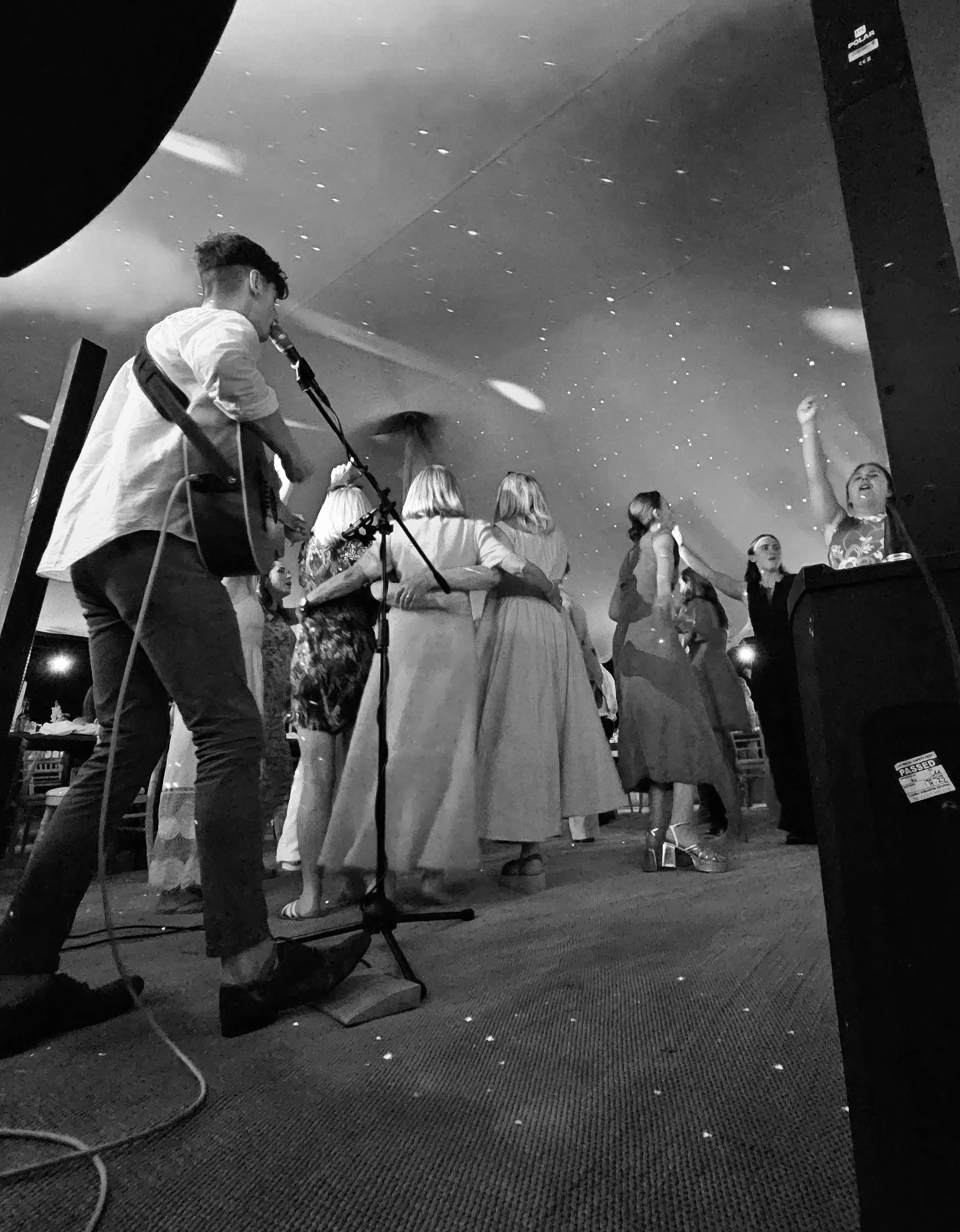 A group of women and a musician performing at a social event with a starry ceiling