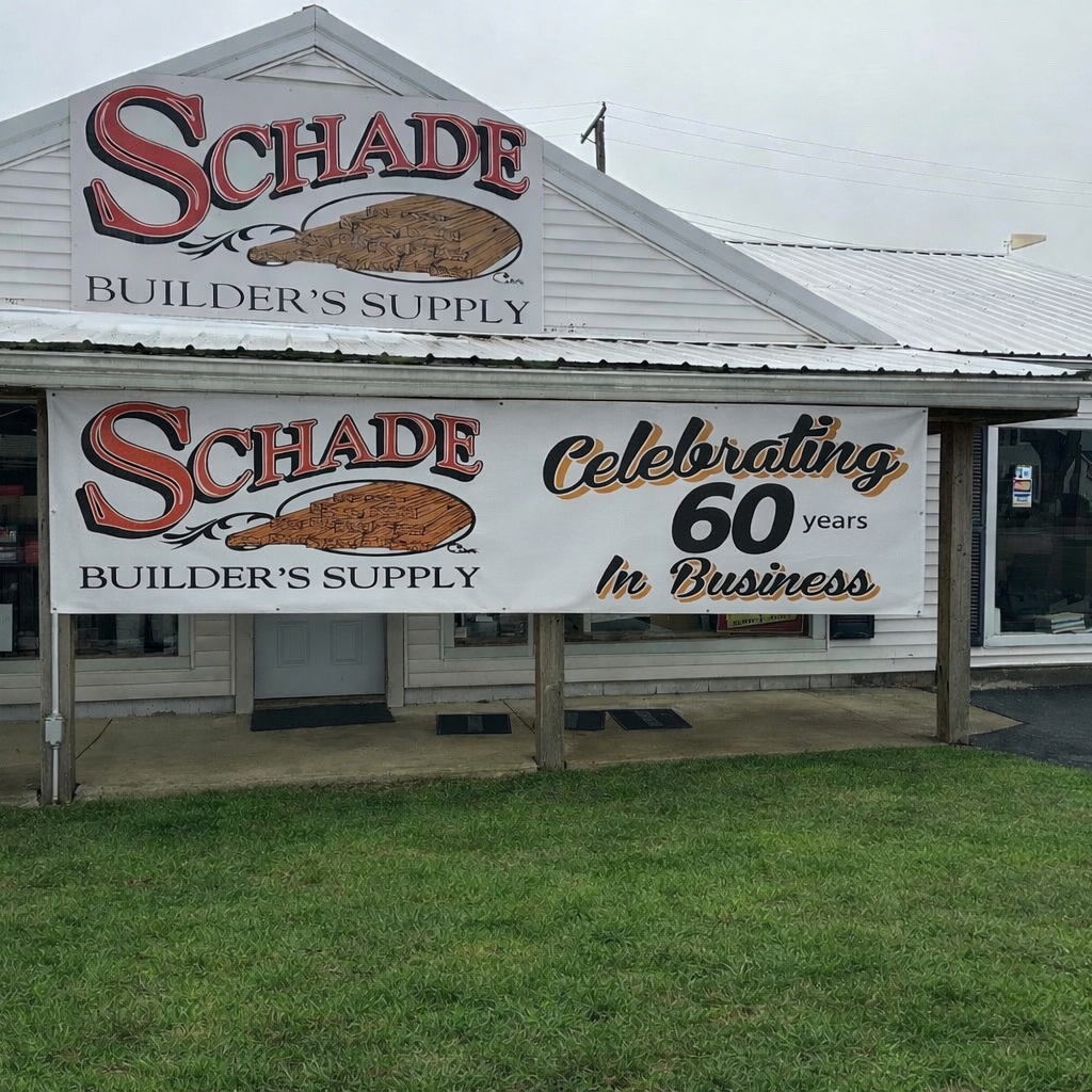 A building with two signs celebrating 60 years in business for Schade Builder's Supply. The signs feature the company's logo and a construction graphic, with the message 'Celebrating 60 years in Business.'