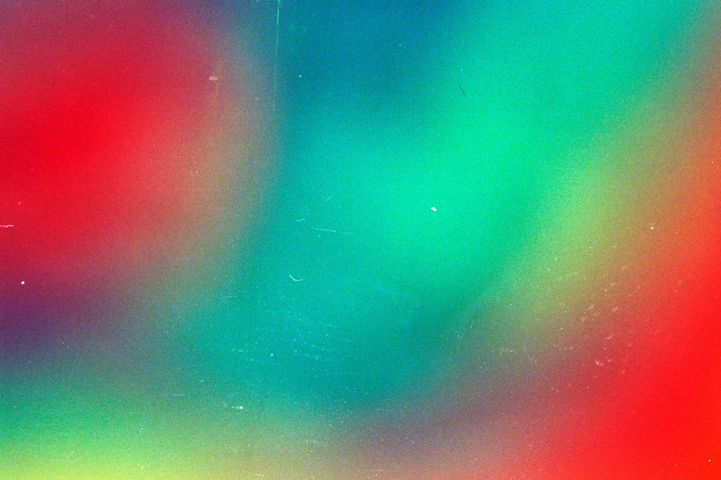 Abstract background with blurred red, green, and blue colors blending together.