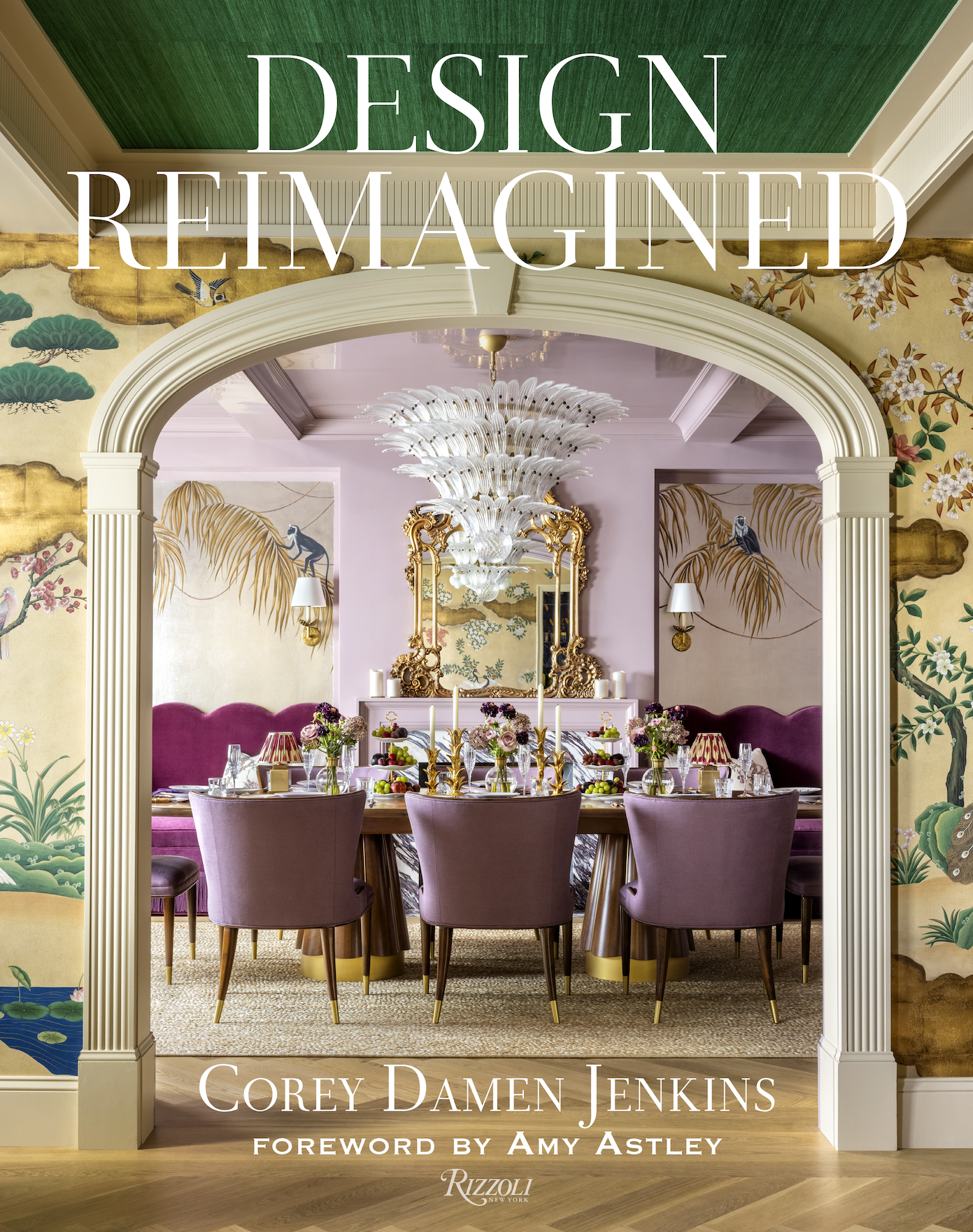 The cover of a book titled 'Design Reimagined' shows an elegant dining room with a large chandelier, a decorated table with floral arrangements and fruit, purple chairs, a pastel purple curtain, and a mural with Asian-inspired landscape art.