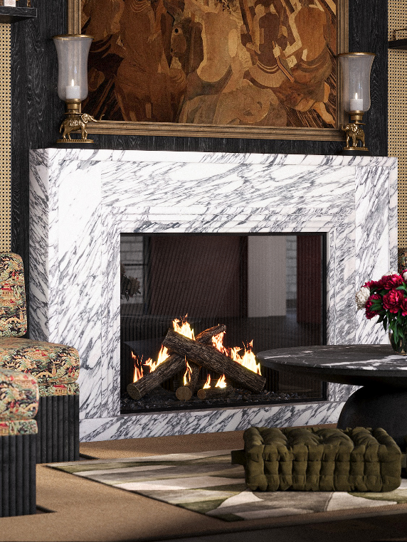 Fireplace with a marble mantel and lit logs, flanked by two candles on gold candle holders, in a living room with floral upholstery, a round table with pink flowers, and a Persian-style rug.