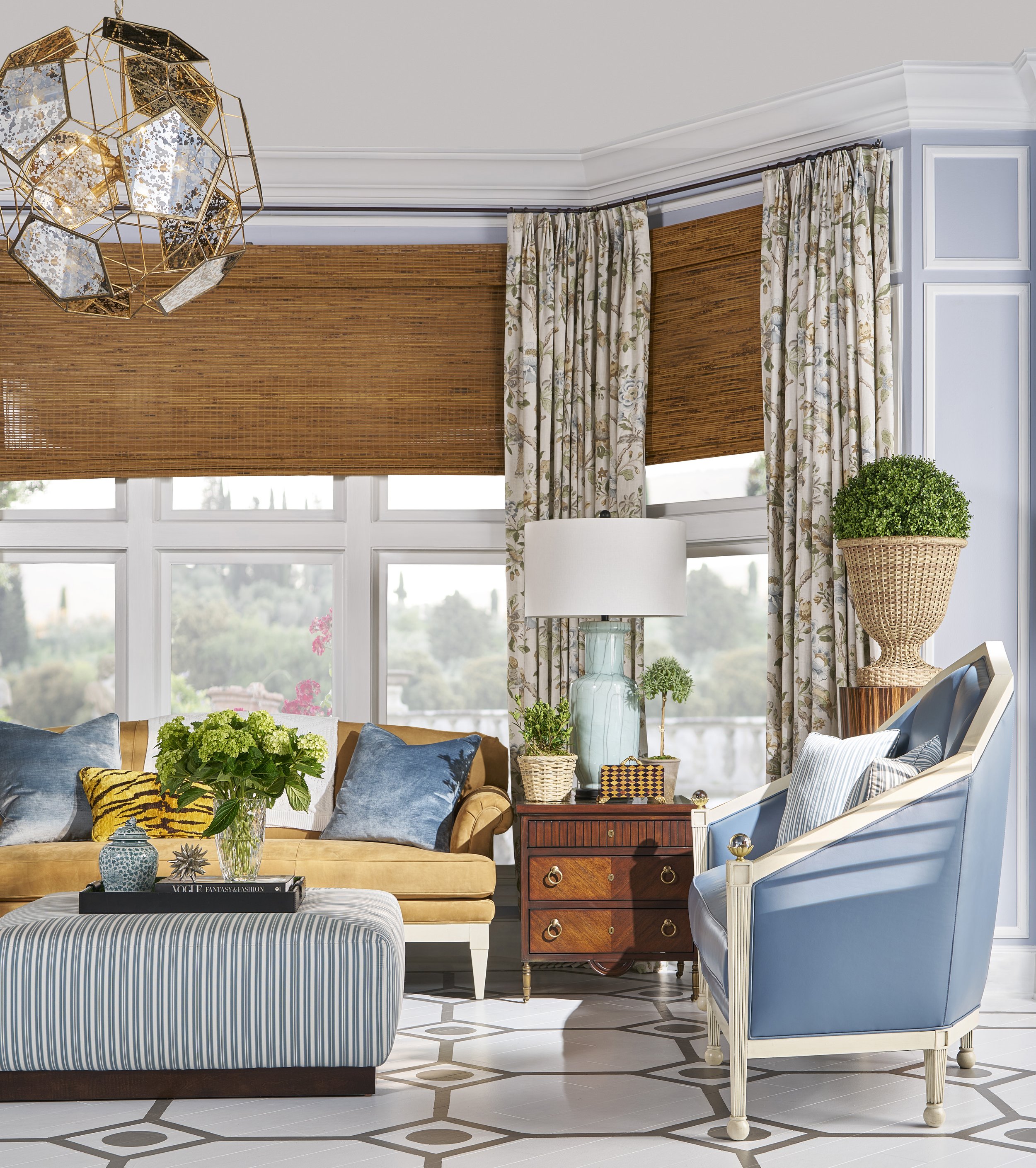 Living room with various furniture, plants, and decorative items including portraits, vases, and a window with curtains.