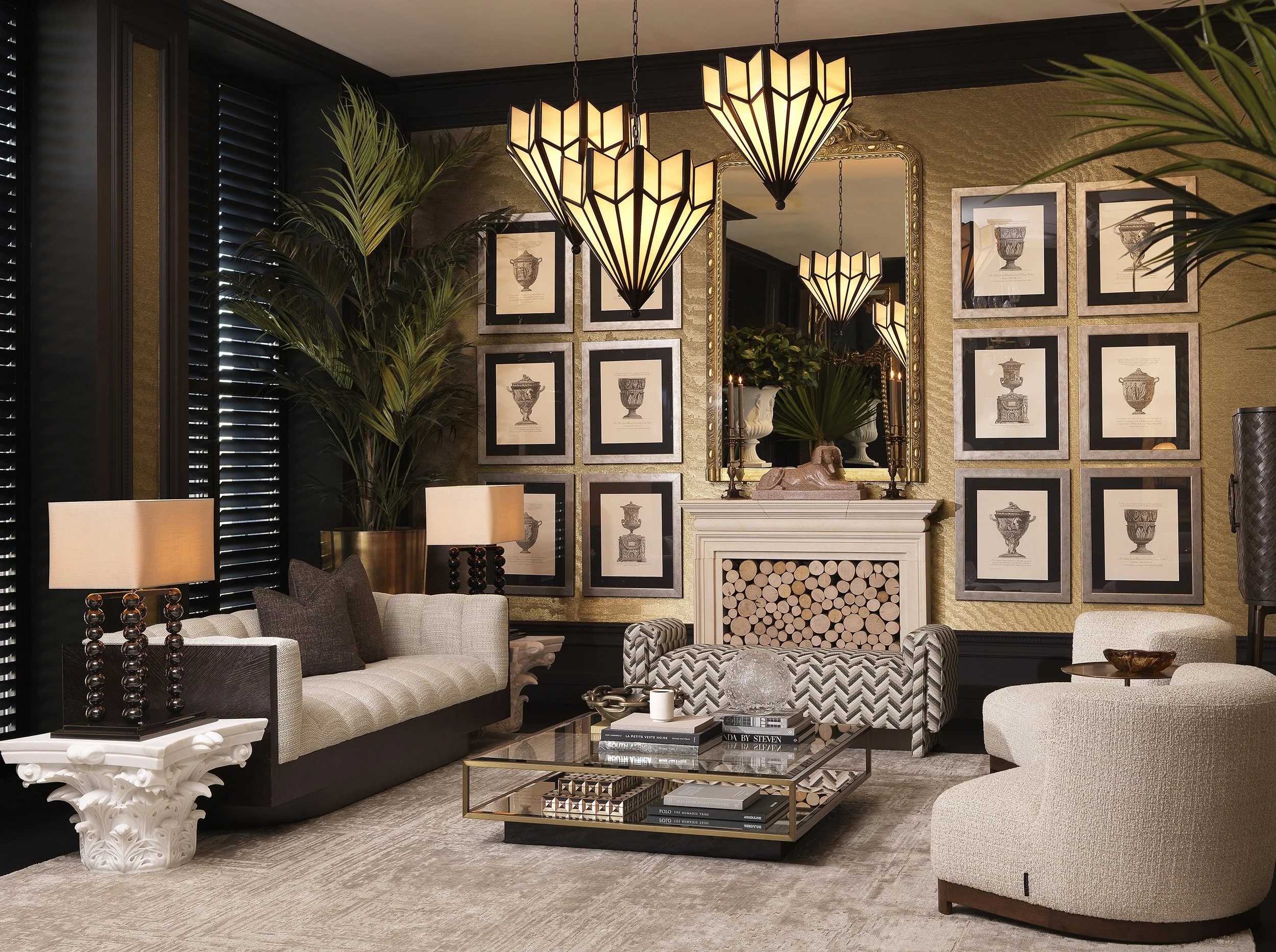Living room with beige sofa, black and white chevron armchair, glass coffee table with books, black window shutters, framed artwork of urns on the wall, ornate mirror, leafy plants, pendant lights with geometric shades, table lamps with black bases, 