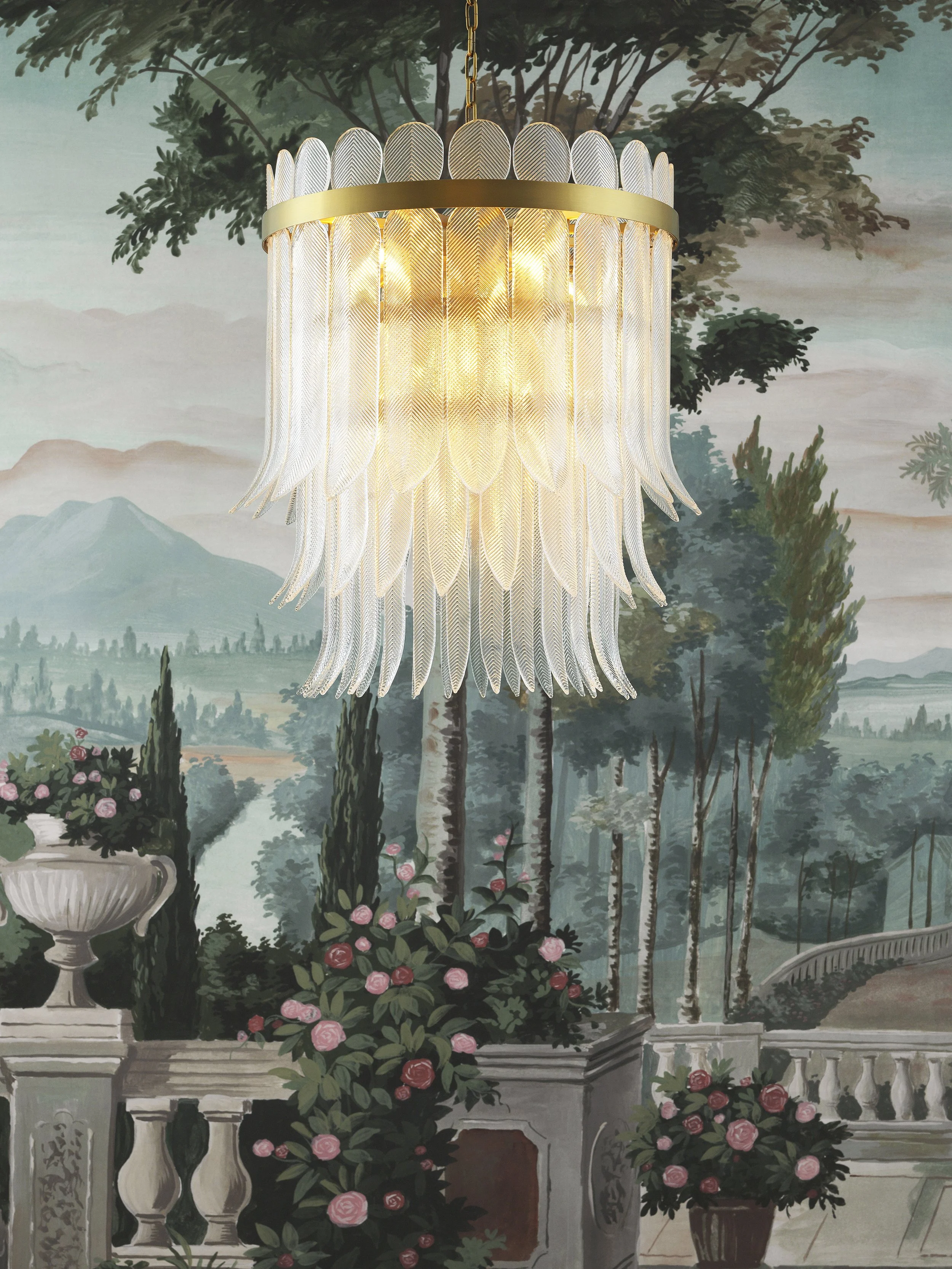 Decorative chandelier hanging in front of a mural of a lush landscape with mountains, trees, and flowering plants.