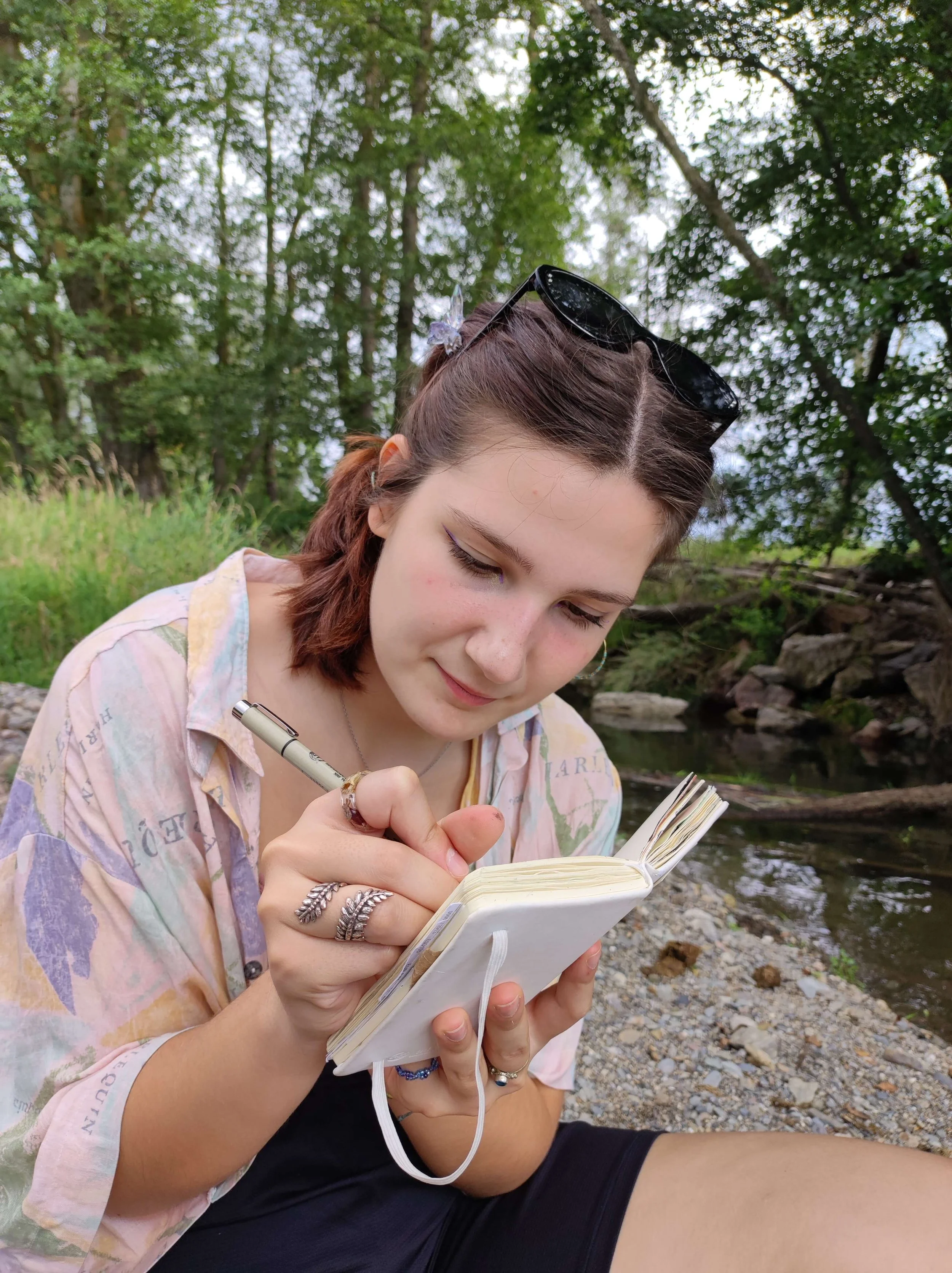 3D artist and concept artist and illustrator drawing in a sketchbook outdoors, reflecting a traditional art foundation.