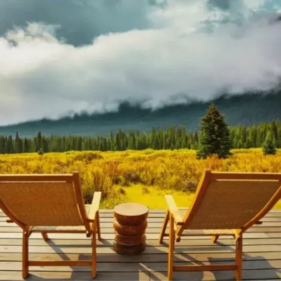 Two empty chairs overlooking a peaceful mountain landscape, symbolizing a shared space for connection.