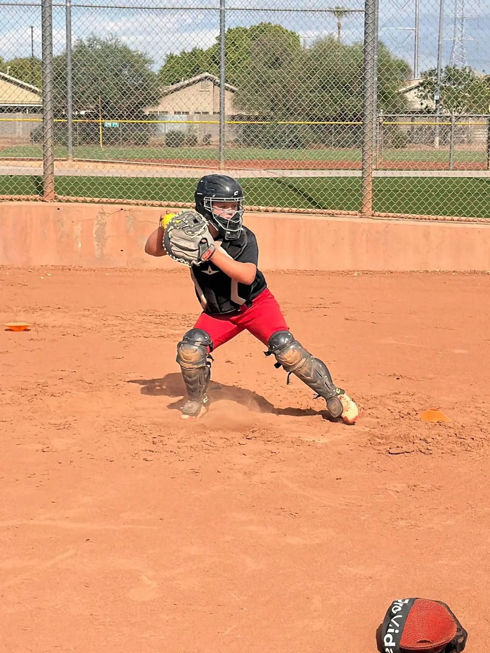Girl catcher in stance ready to throw down to second base.