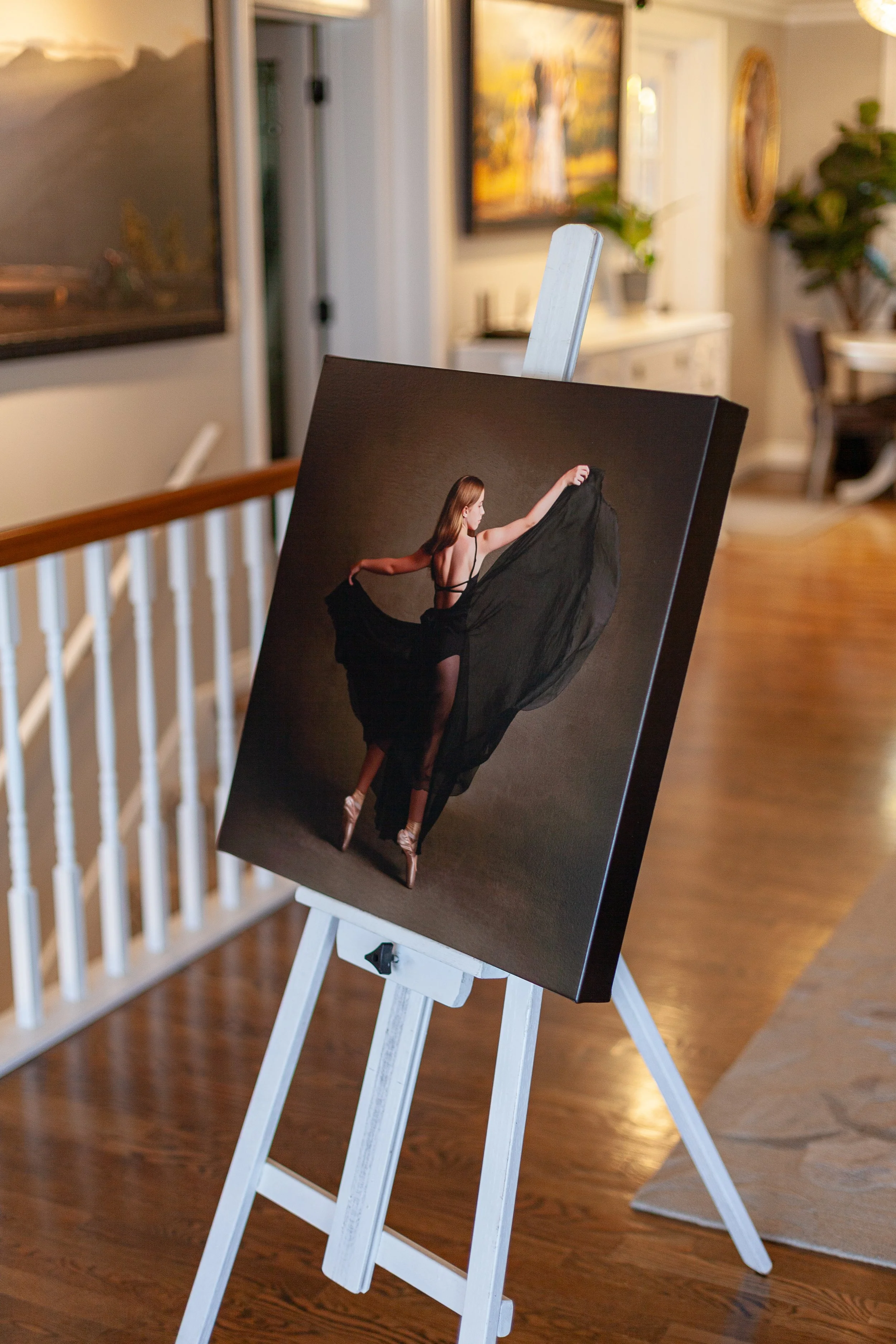 A portrait painting of a ballerina dancing in a black dress with a flowing skirt, standing on pointe shoes.