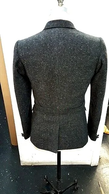 Back view of a dark gray fitted blazer on a white mannequin.