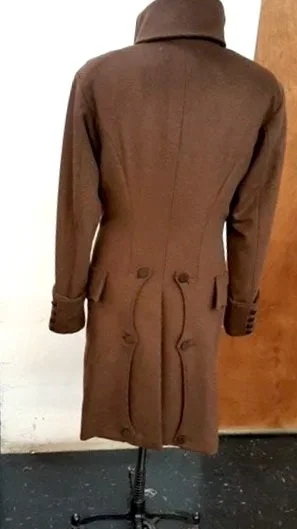 A brown trench coat  back view with a high collar and belt details.