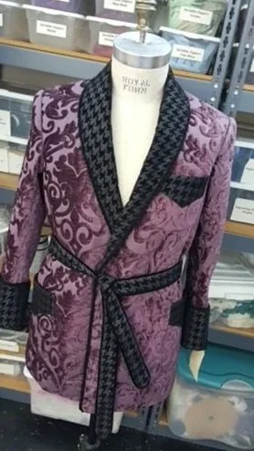 Purple blazer with black patterned lapels and belt.