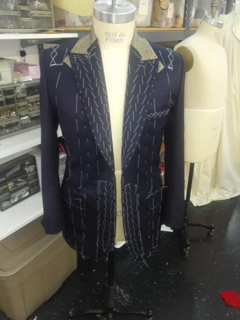 Dark navy blue blazer with a contrasting light beige collar and patterned details