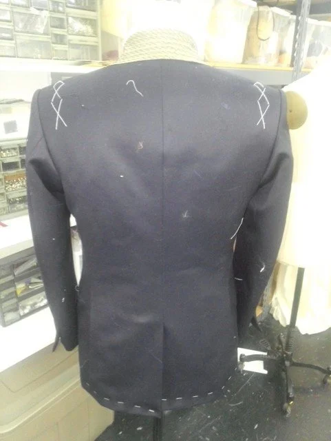 Tailored black blazer with white stitching details on shoulder