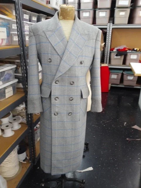 A gray double-breasted overcoat with a plaid pattern displayed