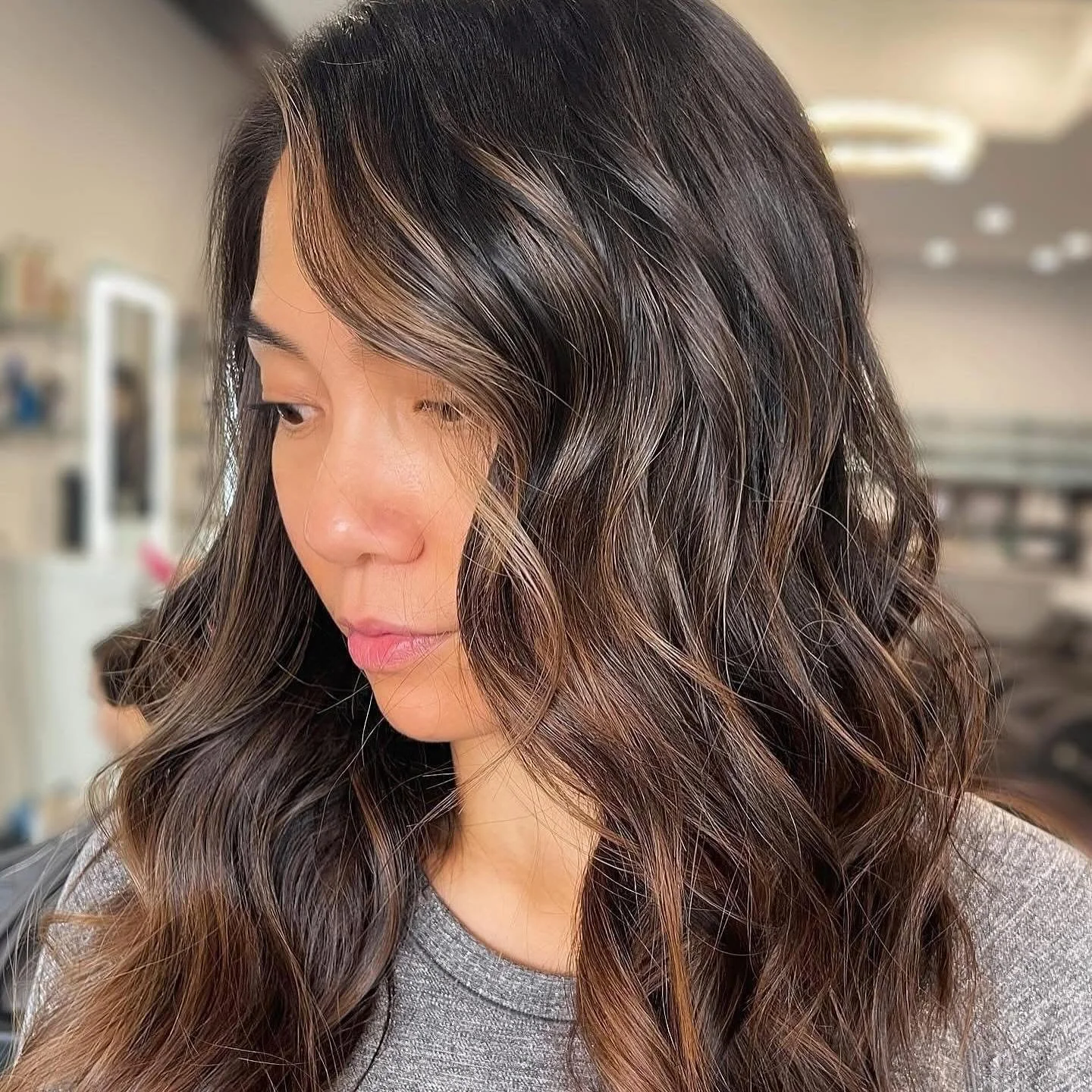 Close-up of a woman with wavy, highlighted hair.