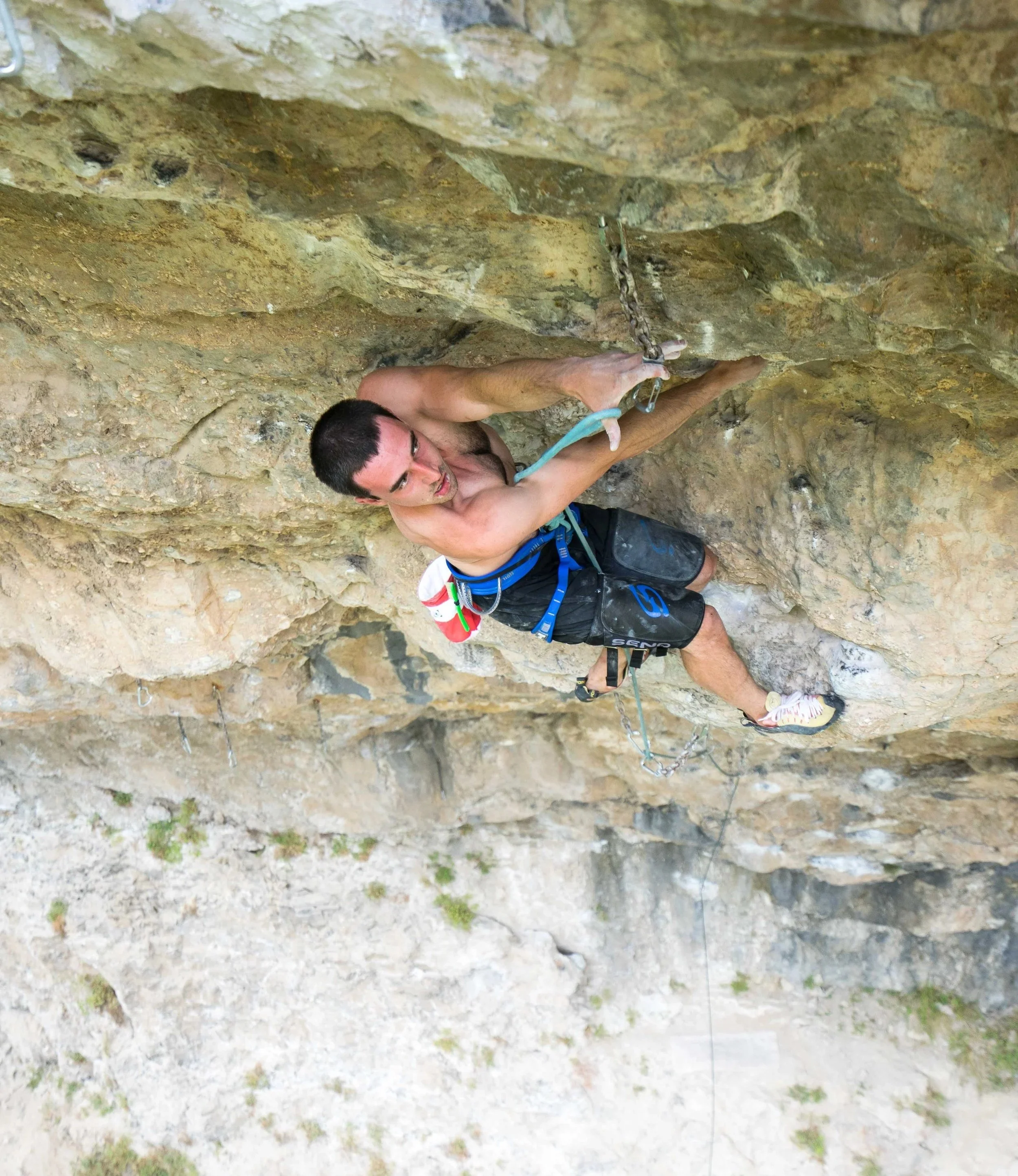 Man rock climbing on an outdoor rock face with climbing gear