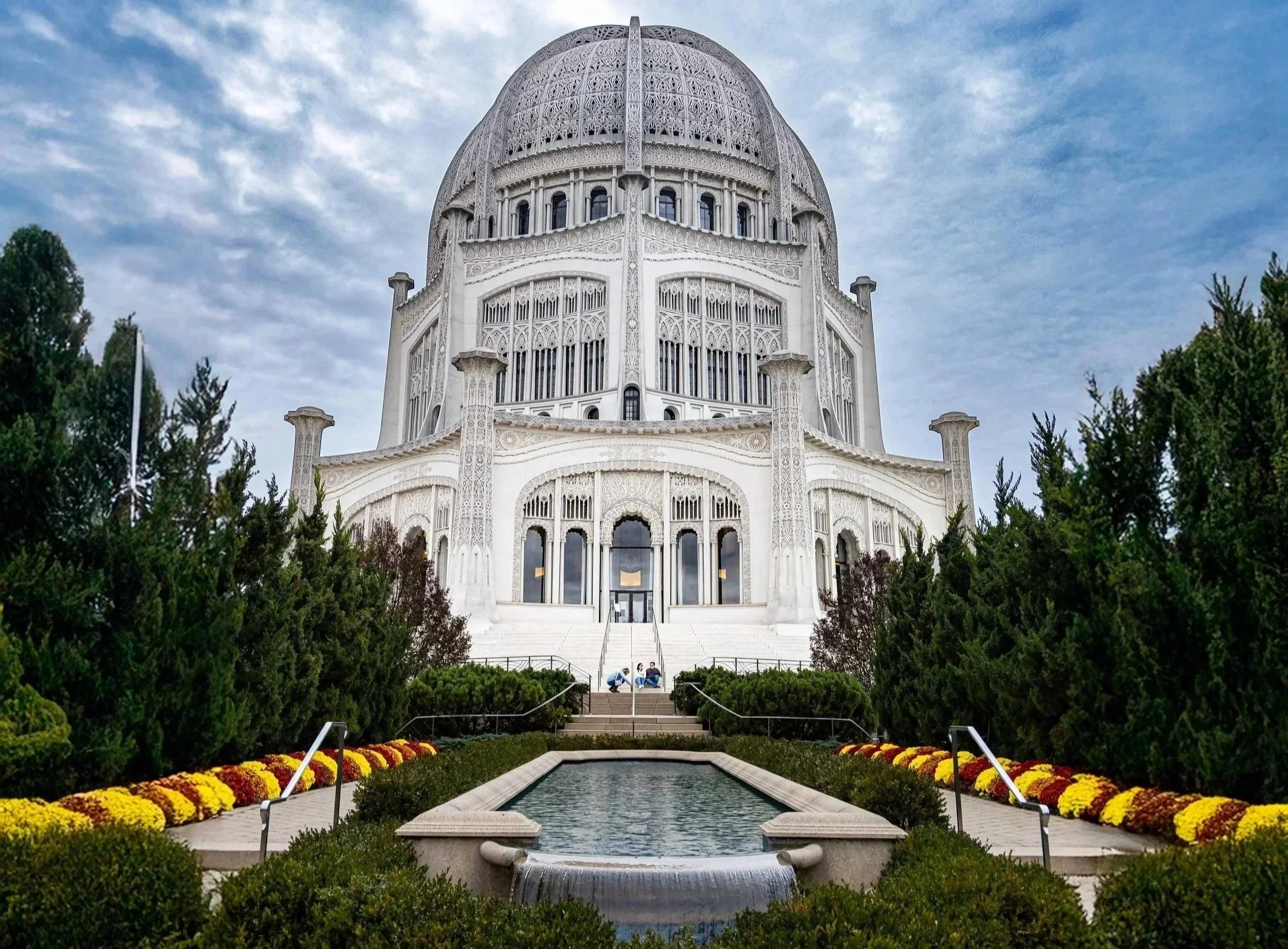 The Salt Lake Temple in Salt Lake City, Utah, Bhai temple with detailed gothic architecture, surrounded by trees and colorful flowers, with a small fountain in the foreground. Place of worship rising to the heaven.