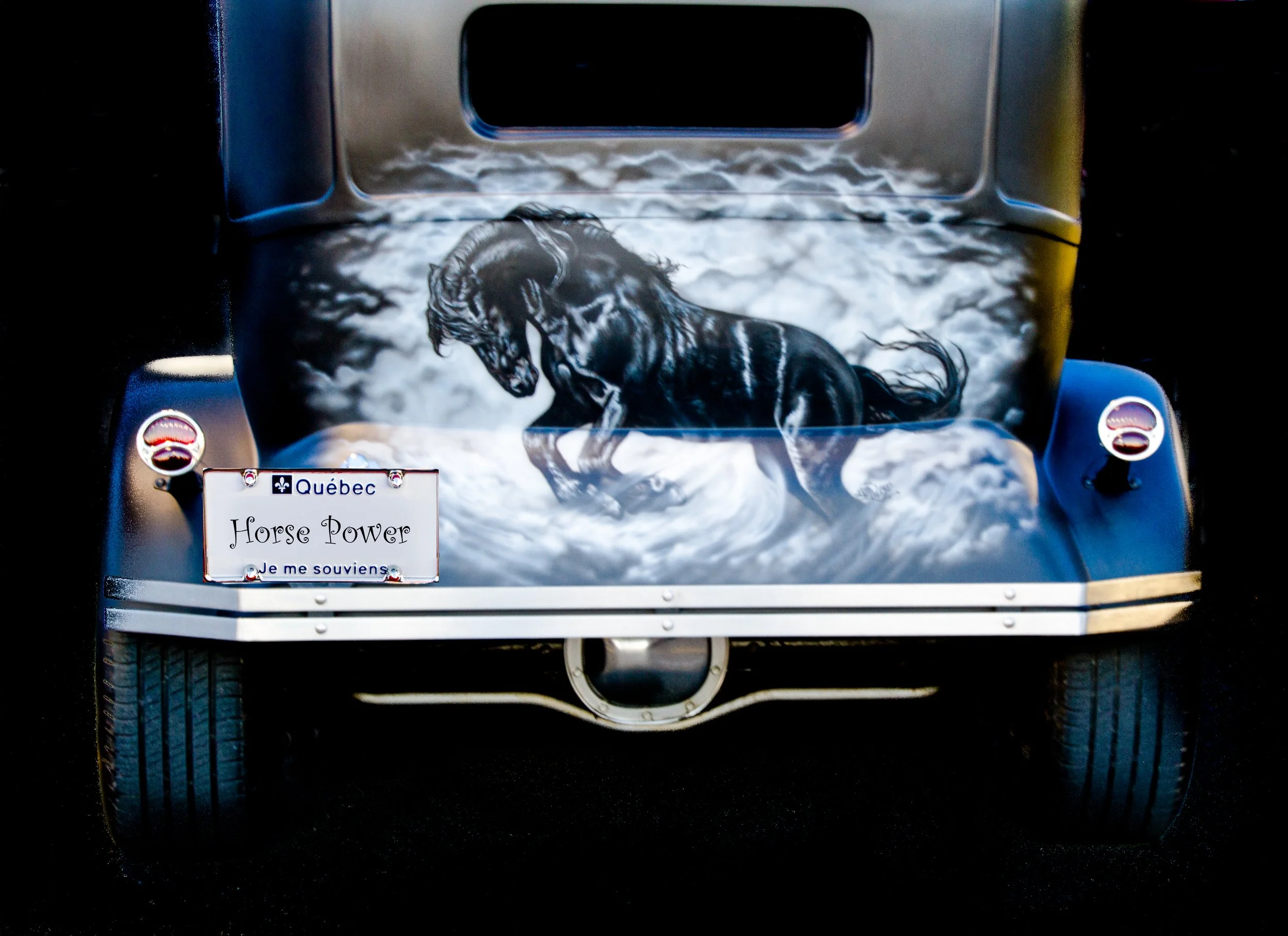 Car with custom artwork of a black horse running through water on the hood, Quebec license plate reading "Horse Power," and the phrase "Je me souviens"