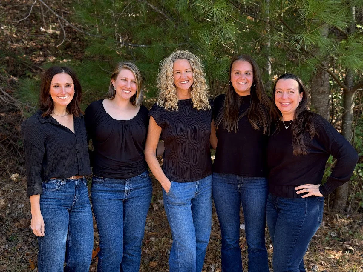 Parkview Dental's dental hygienist team of five women standing outside smiling in front of green trees