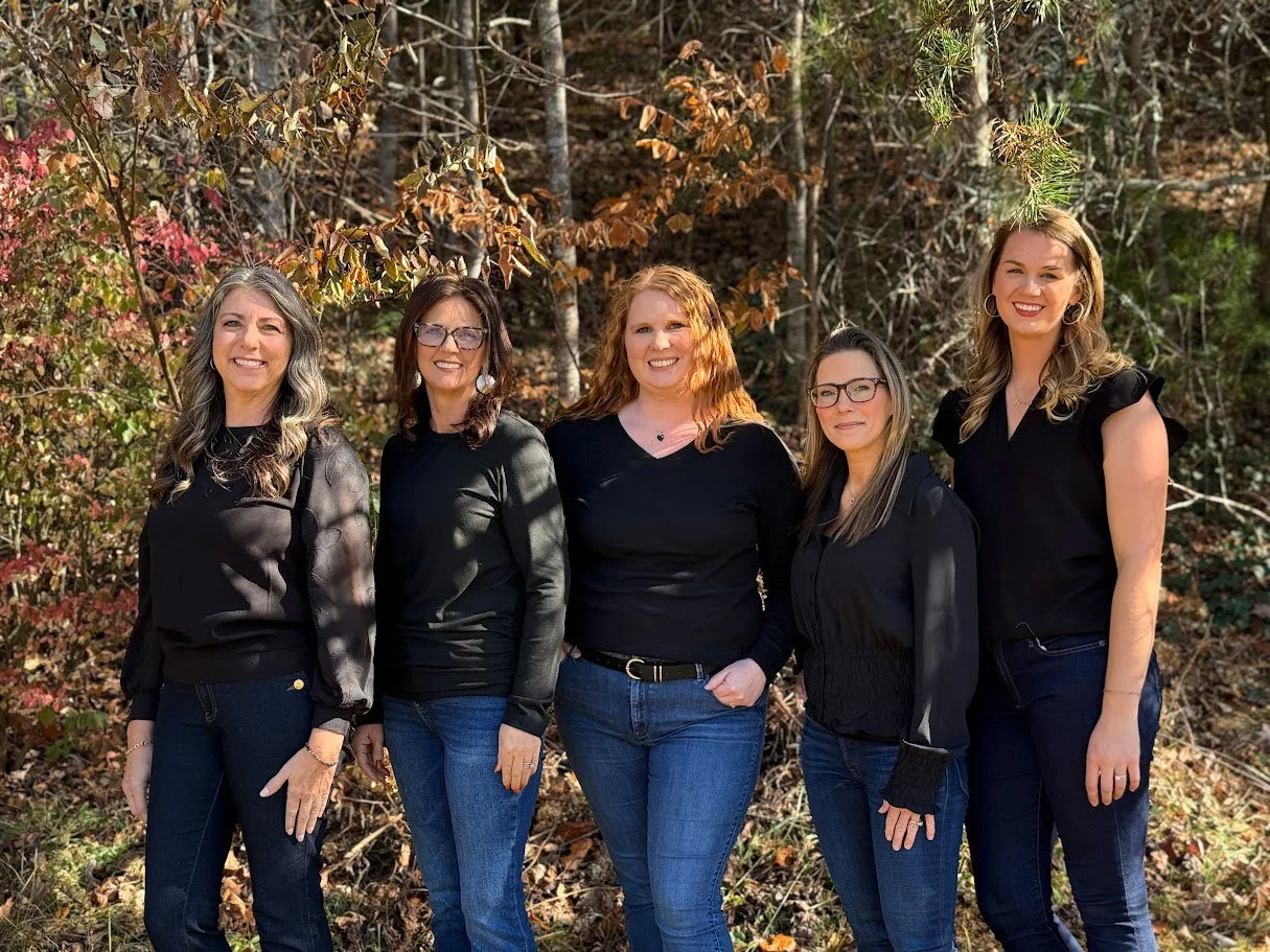 Parkview Dental's administrative team of 5 women standing outside smiling wearing black shirts and blue jeans