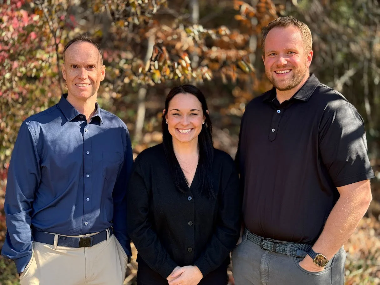 Parkview Dental dentists Dr. Stacey, Dr. Pressley, and Dr. Holt standing outside smiling in front of trees