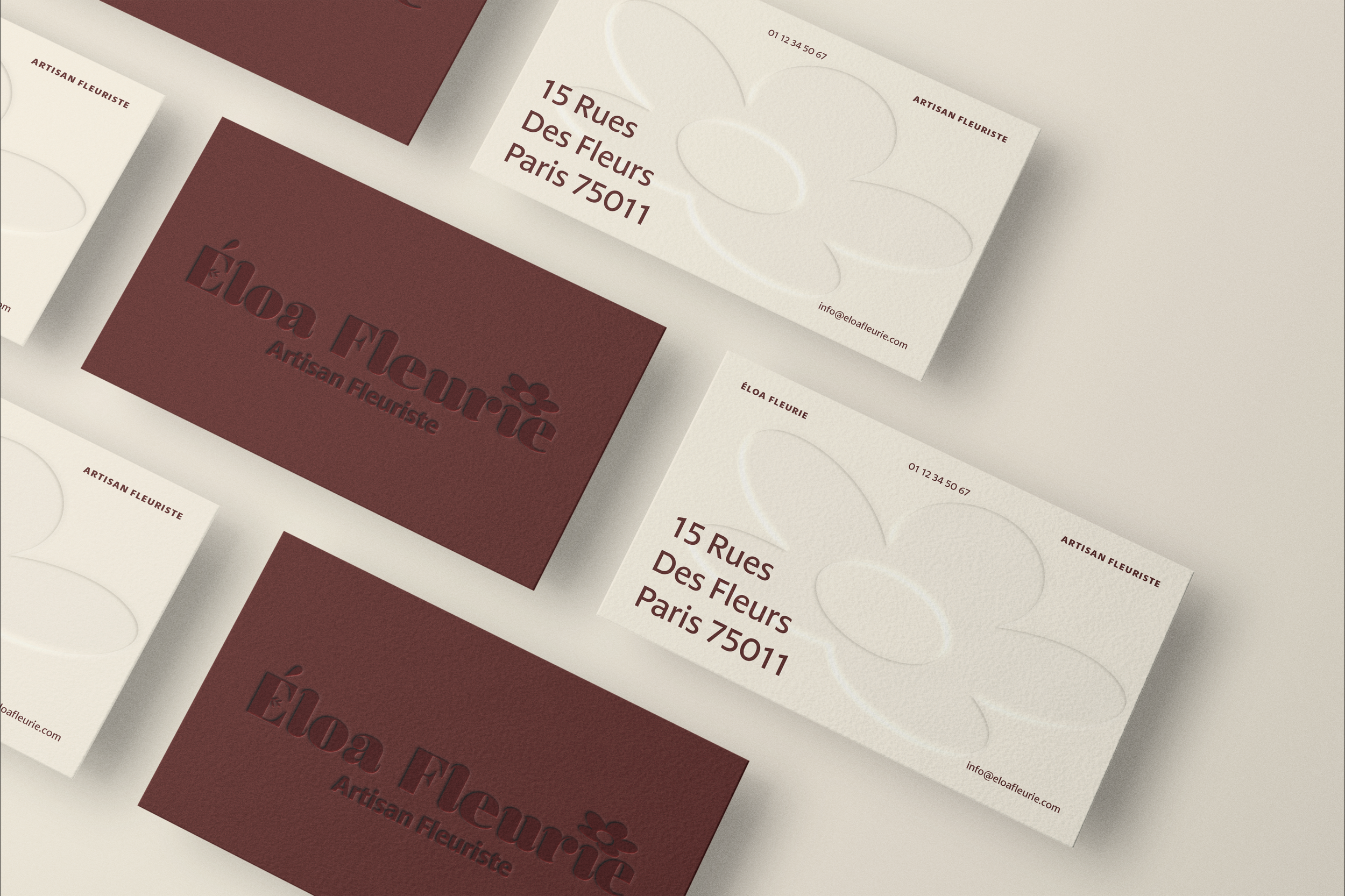 Cartes de visite pour une fleuriste nommée Éloa Fleurie, avec adresse, téléphone, et logo en relief sur fond blanc et rouge.