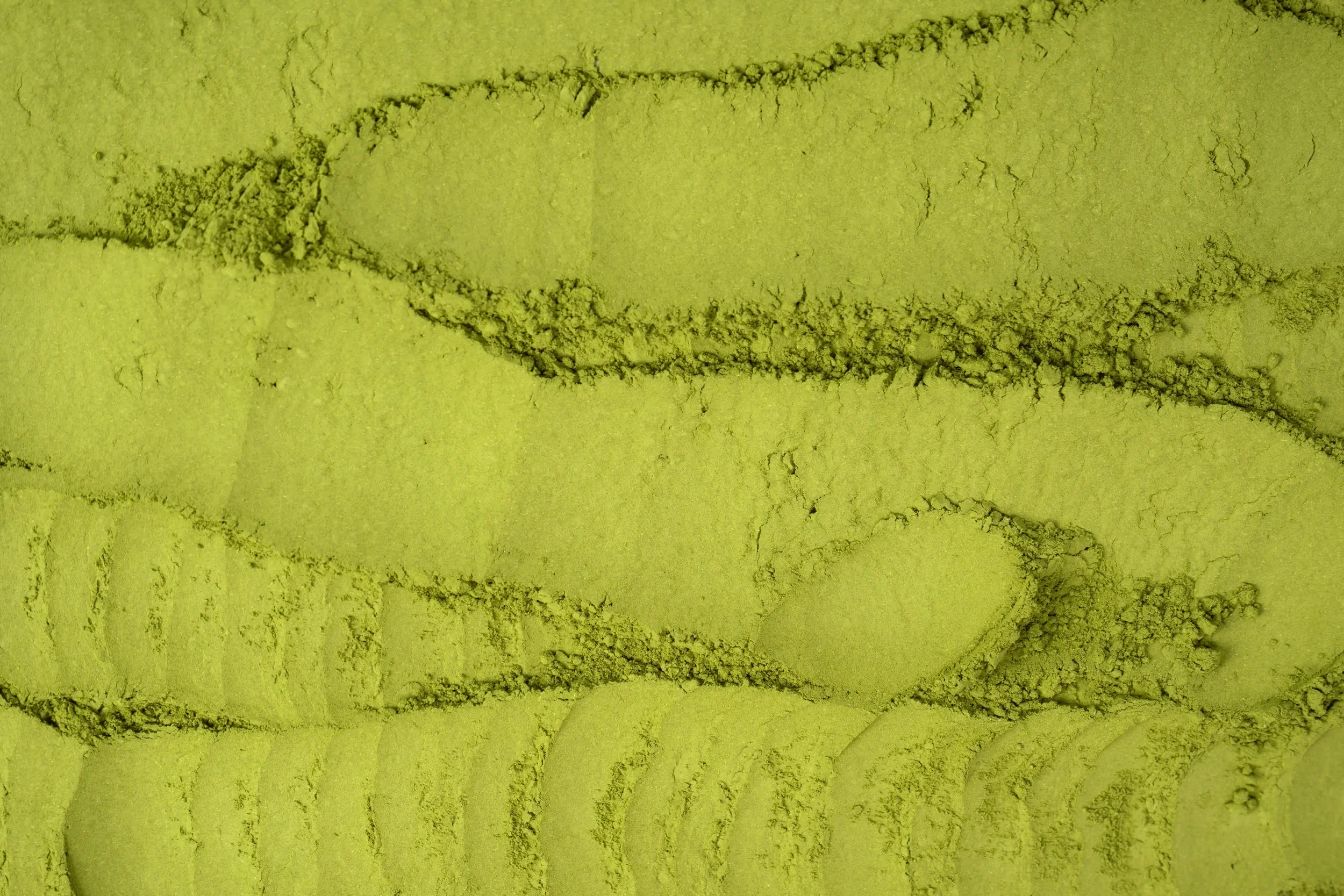 Une surface de pierre jaune avec des fissures et des traces de craquelures.