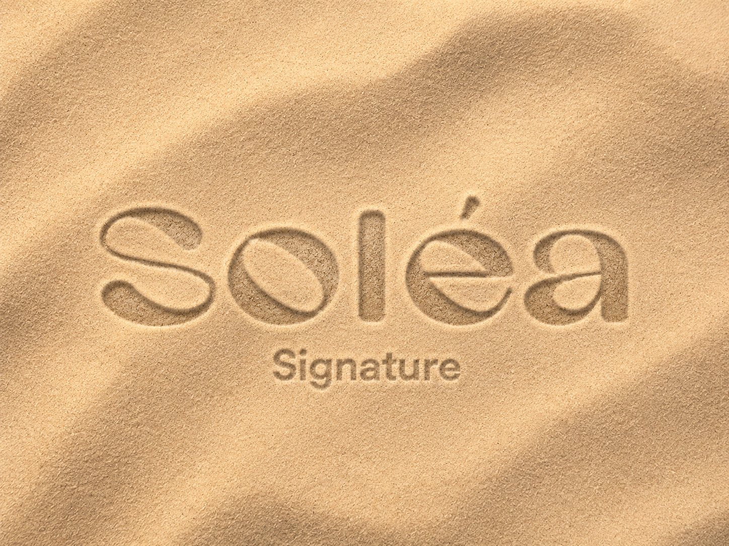 Le mot « soléa » écrit dans le sable avec l'inscription « Signature » en dessous.