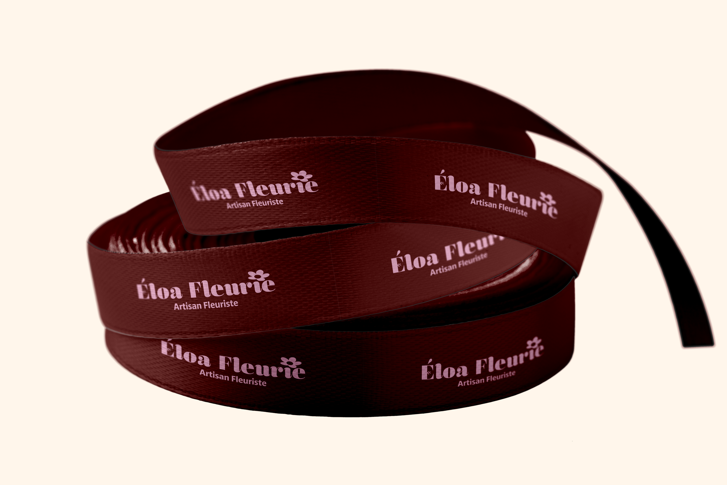 Une bobine de ruban adhésif de couleur rouge foncé avec l'inscription 'Éloà Fleurie Artisanal Fleriste' en blanc chaque tour.