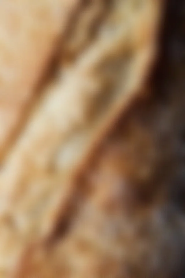 L'image est floue, difficile à identifier précisément, mais semble montrer une matière ou surface de couleur beige ou brune, possiblement du bois ou de la nourriture.