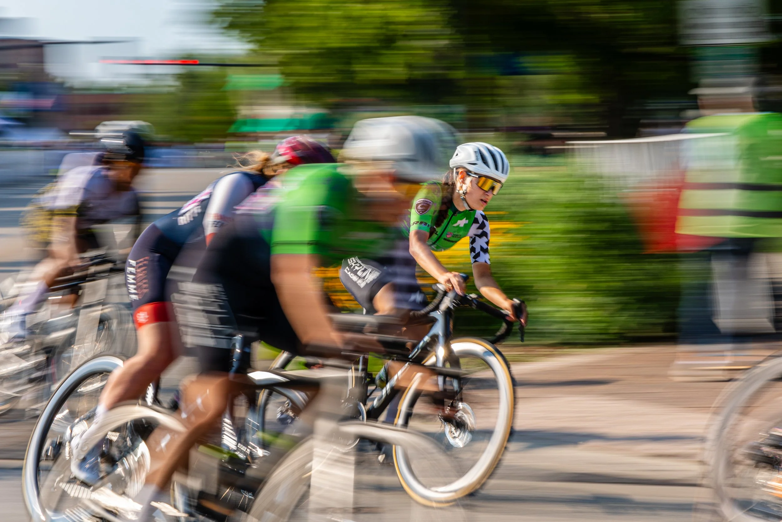 Cyclists racing on a city street, motion blur showing speed and movement.