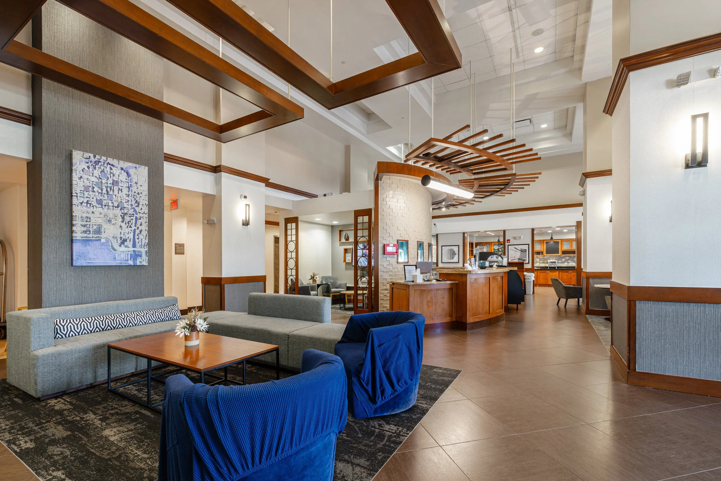 Hotel lobby with seating area, reception desk, and decorative ceiling design.
