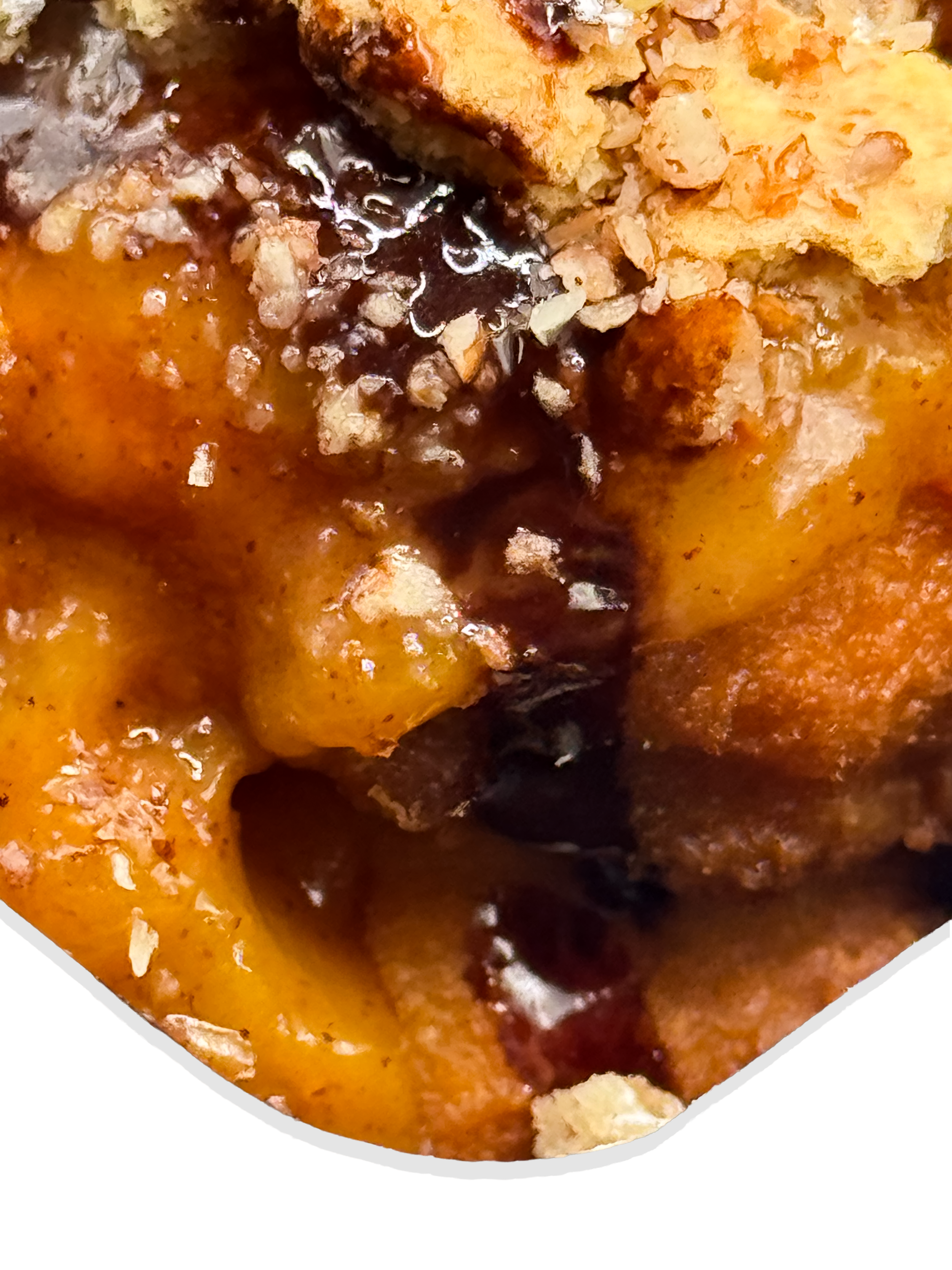 Close-up of a deep fried pound cake topped with peach cobbler and chocolate drizzle.