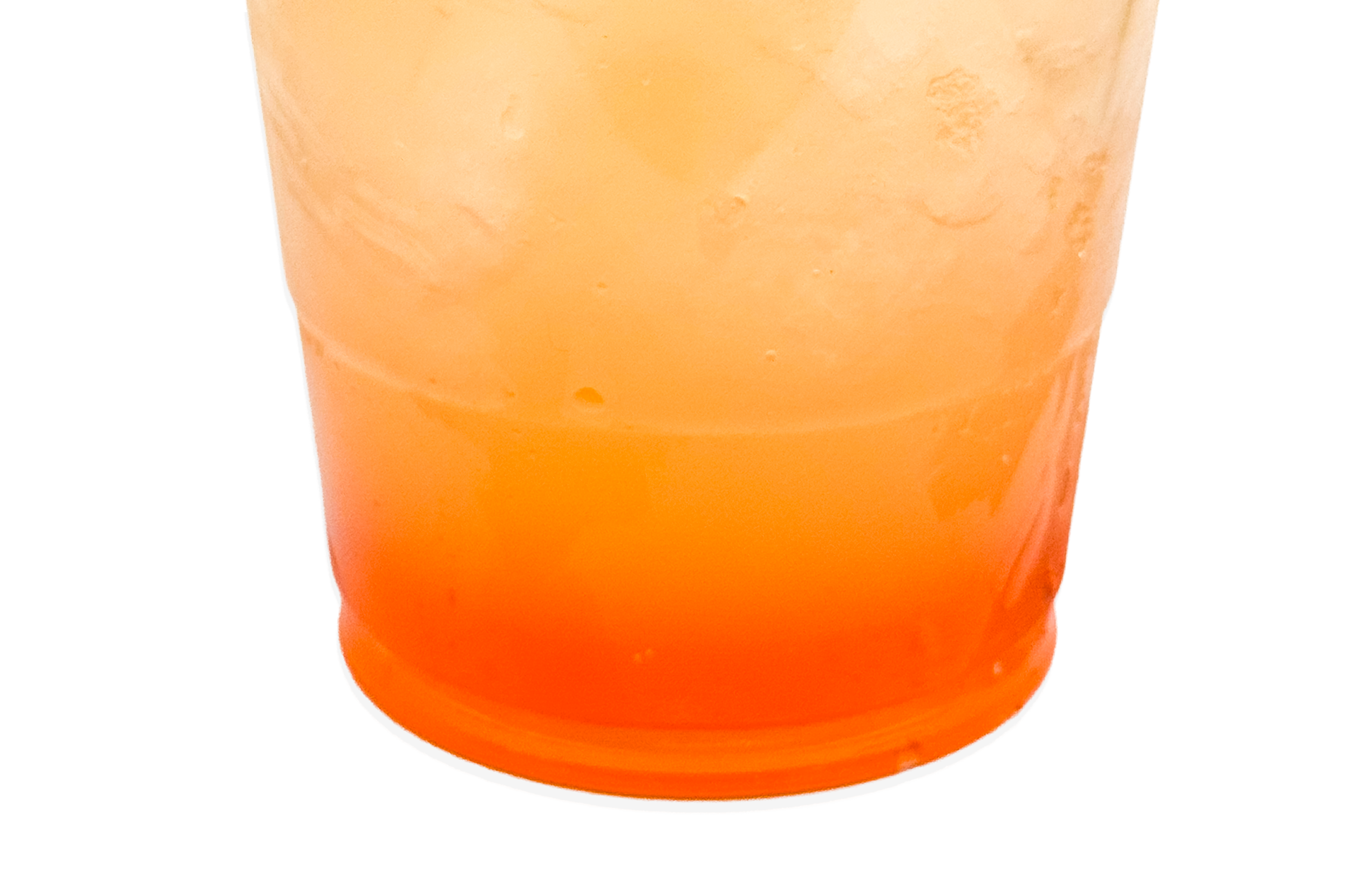 Close-up of a glass filled with orange-colored beverage, showing a gradient from darker at the bottom to lighter at the top.