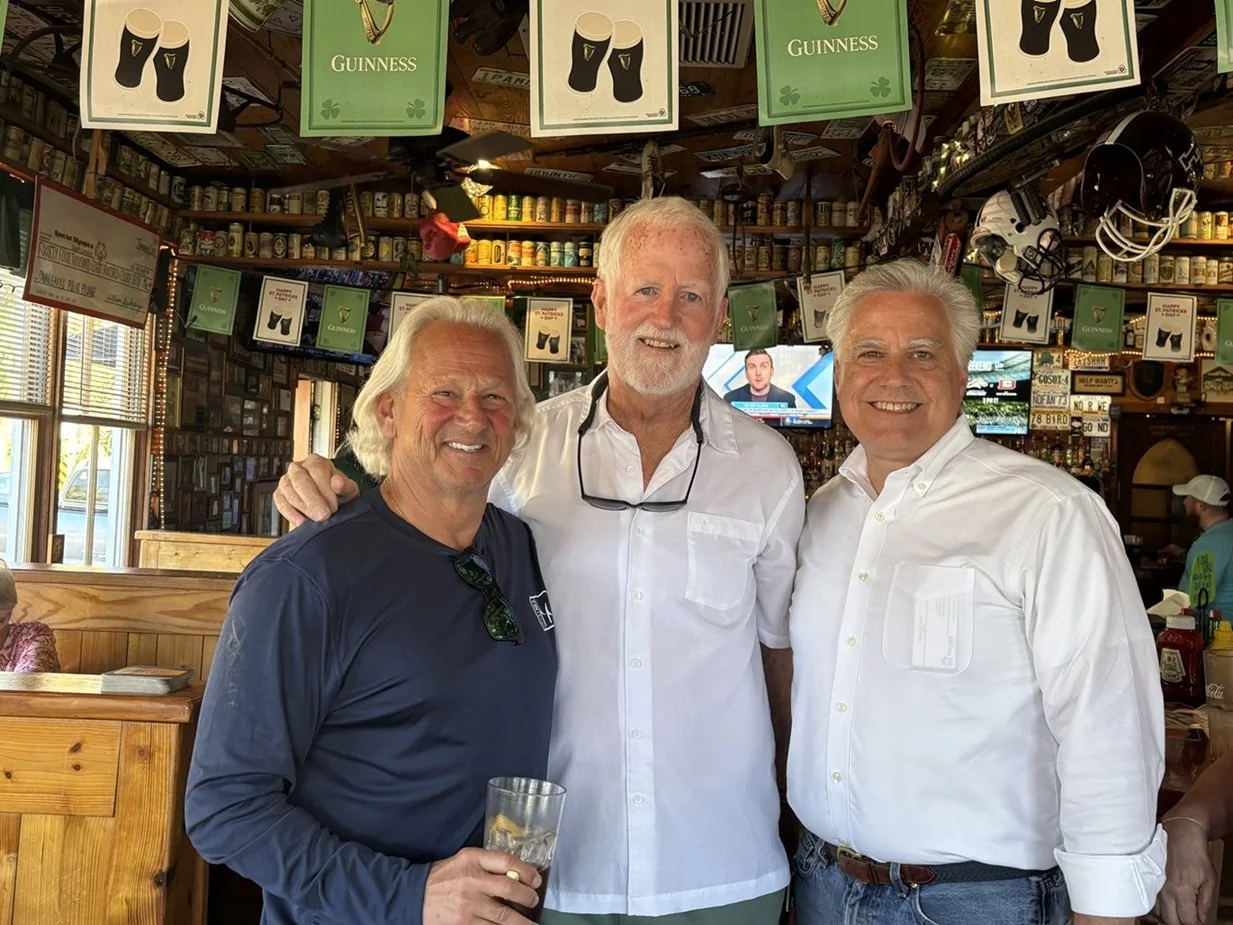 3 smiling men at an event