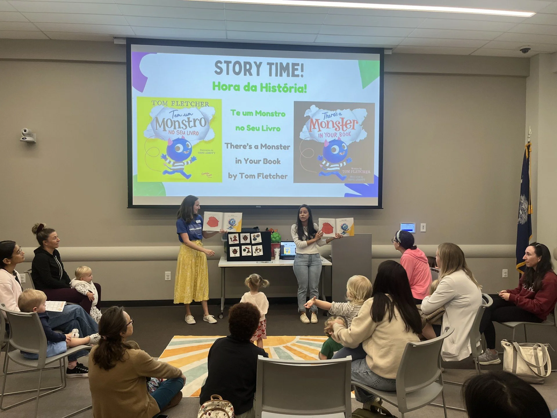 2 leaders holding books at bilingual story time