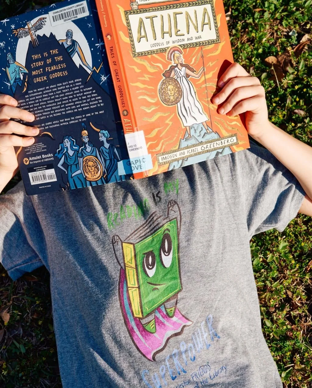 child laying on back reading a book