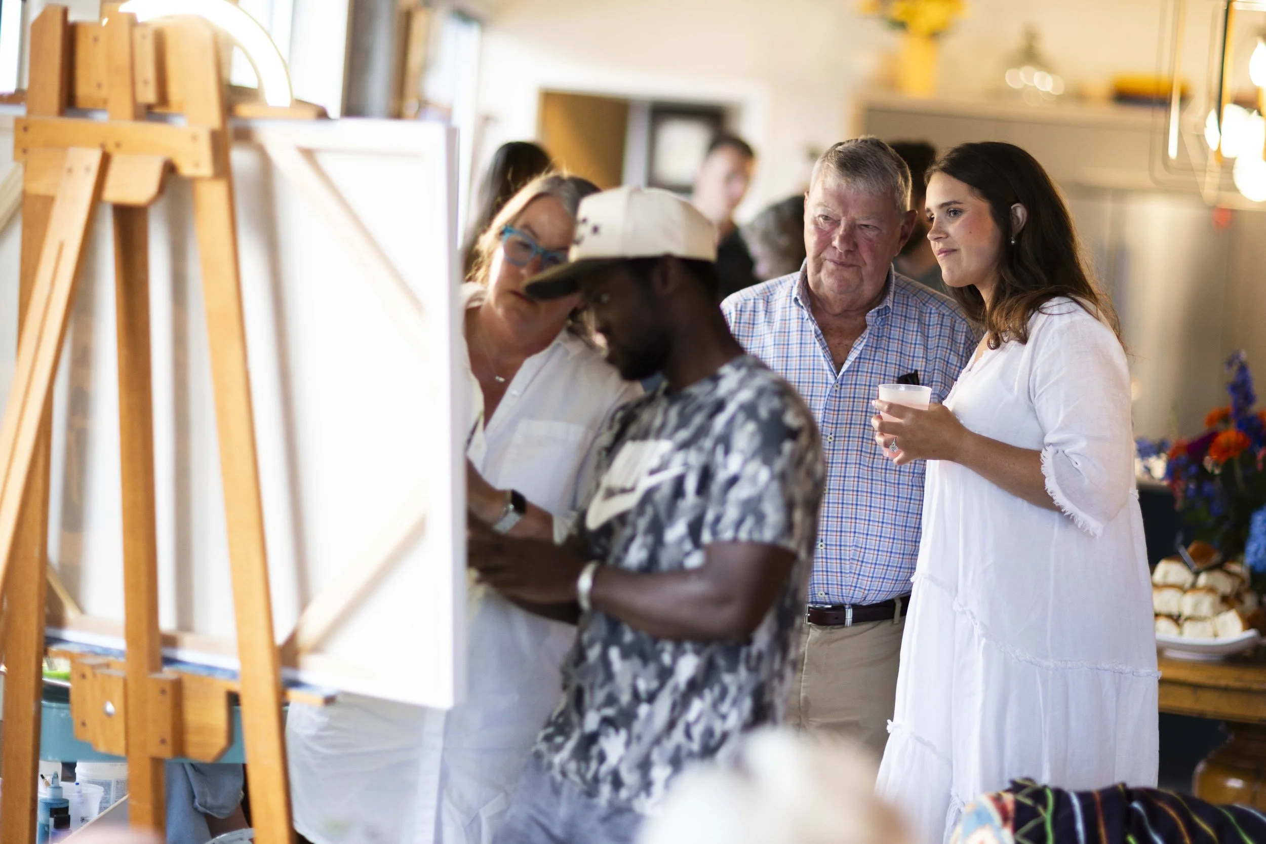 People looking at artwork or photographs on display at an event or gallery.