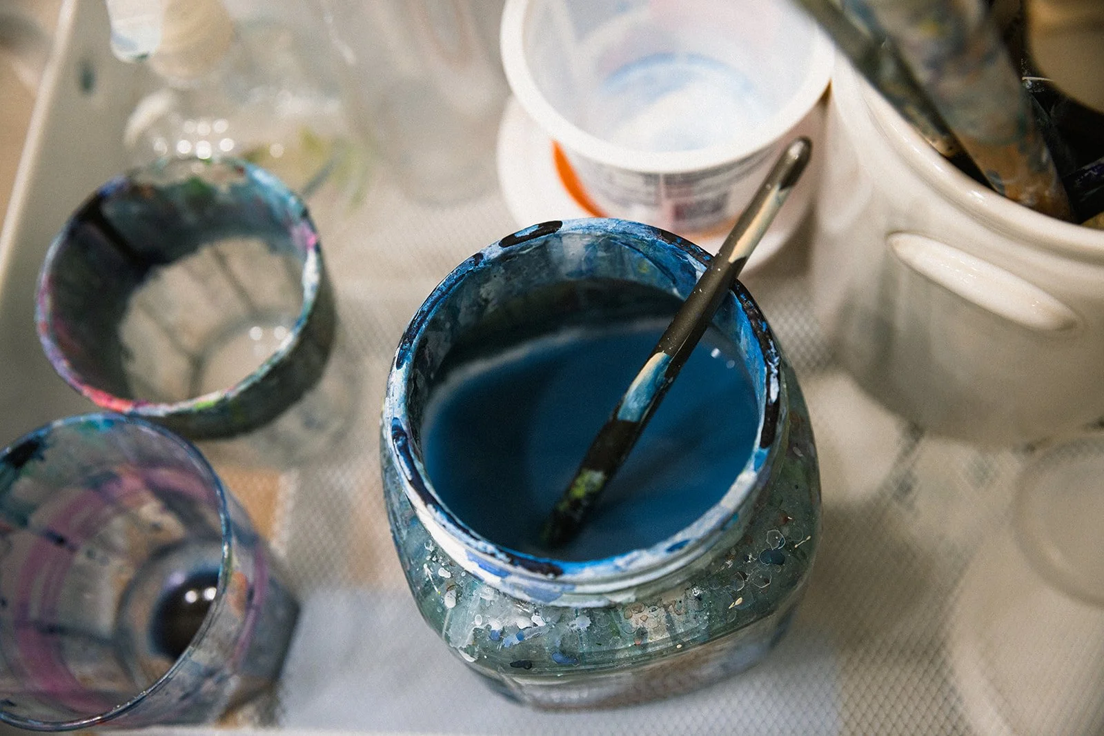 Painting supplies with jars, brushes, and blue paint