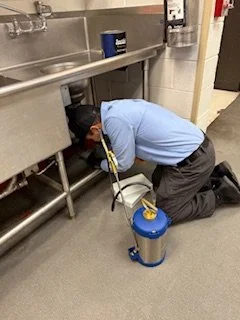 A pest control technician inspecting a commercial kitchen