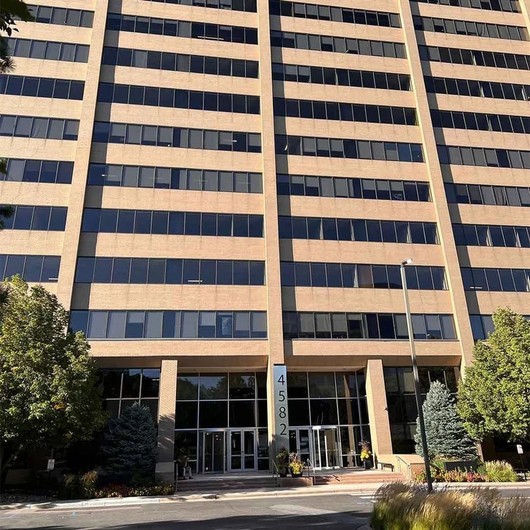 Apex Pest Management technician performing pest control service at a commercial office building in Denver, Colorado.